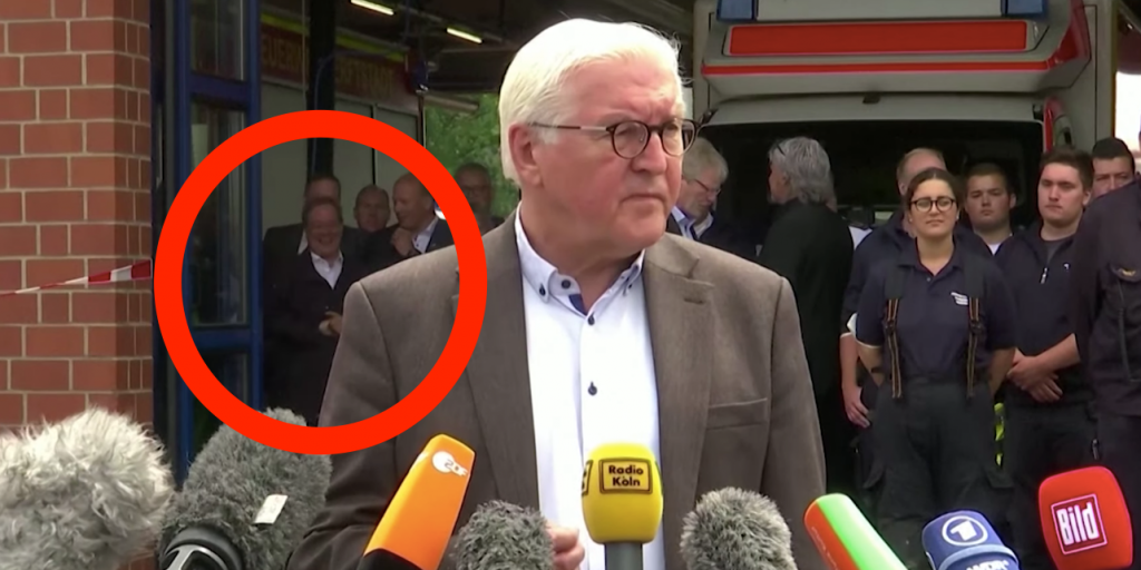 CDU-leider Armin Laschet lacht op de achtergrond.
