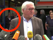 CDU-leider Armin Laschet lacht op de achtergrond.
