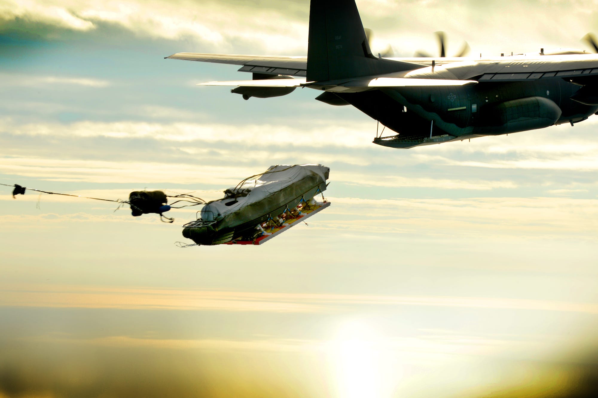 An MC-130J airdrops a boat