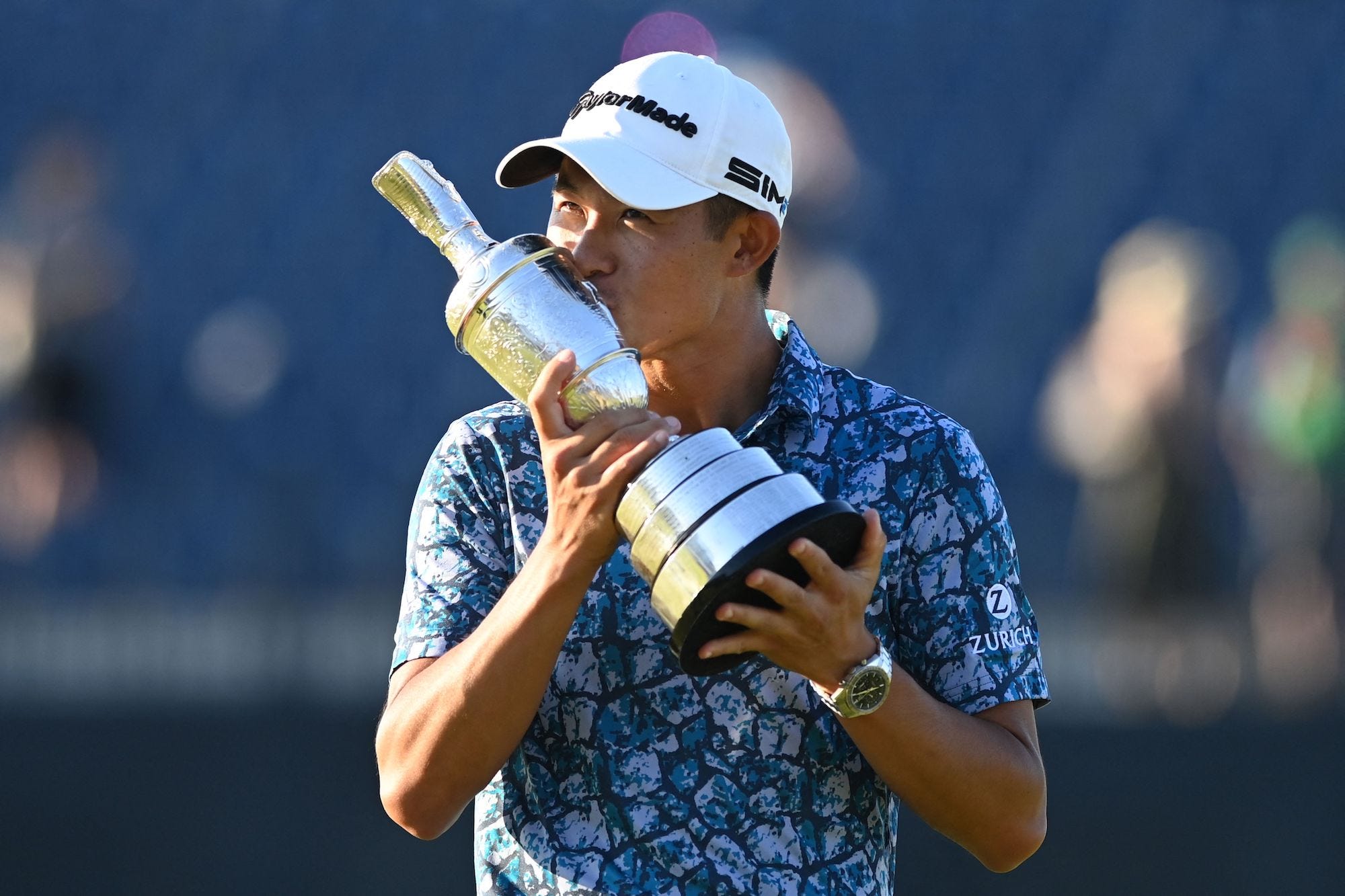 US golfer Collin Morikawa kisses the trophy as he poses for pictures with the Claret Jug, the trophy for the Champion Golfer of the Year, after winning the 149th British Open Golf Championship at Royal St George's, Sandwich in south-east England