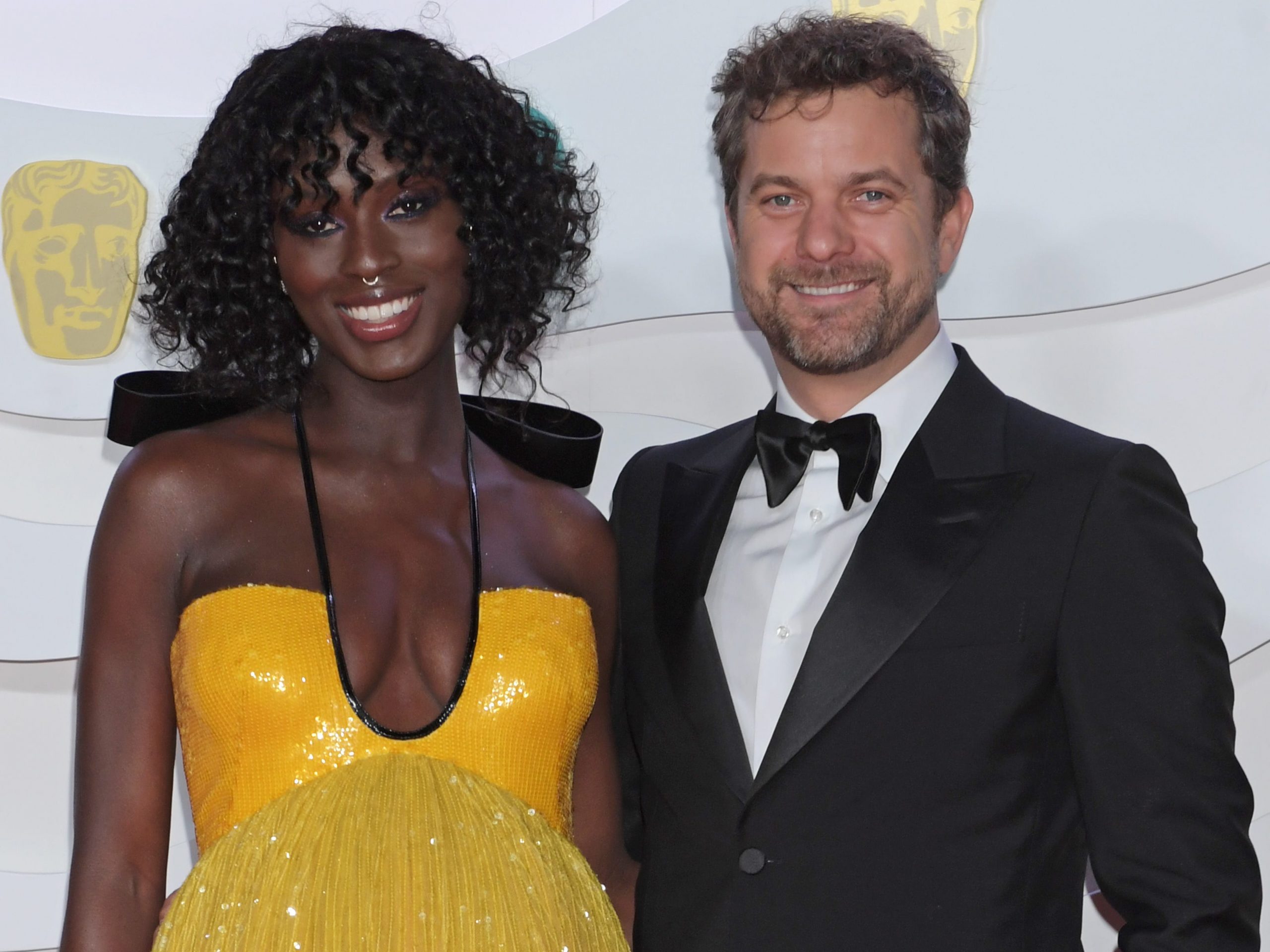 A mixed raced couple posing on the red carpet.