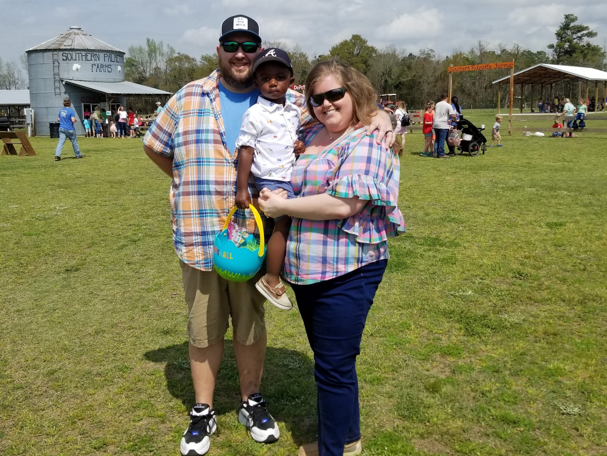 Matthew and Rachel Moore stand in field with their now 3-year-old son, Marshall, who's holding an Easter basket.