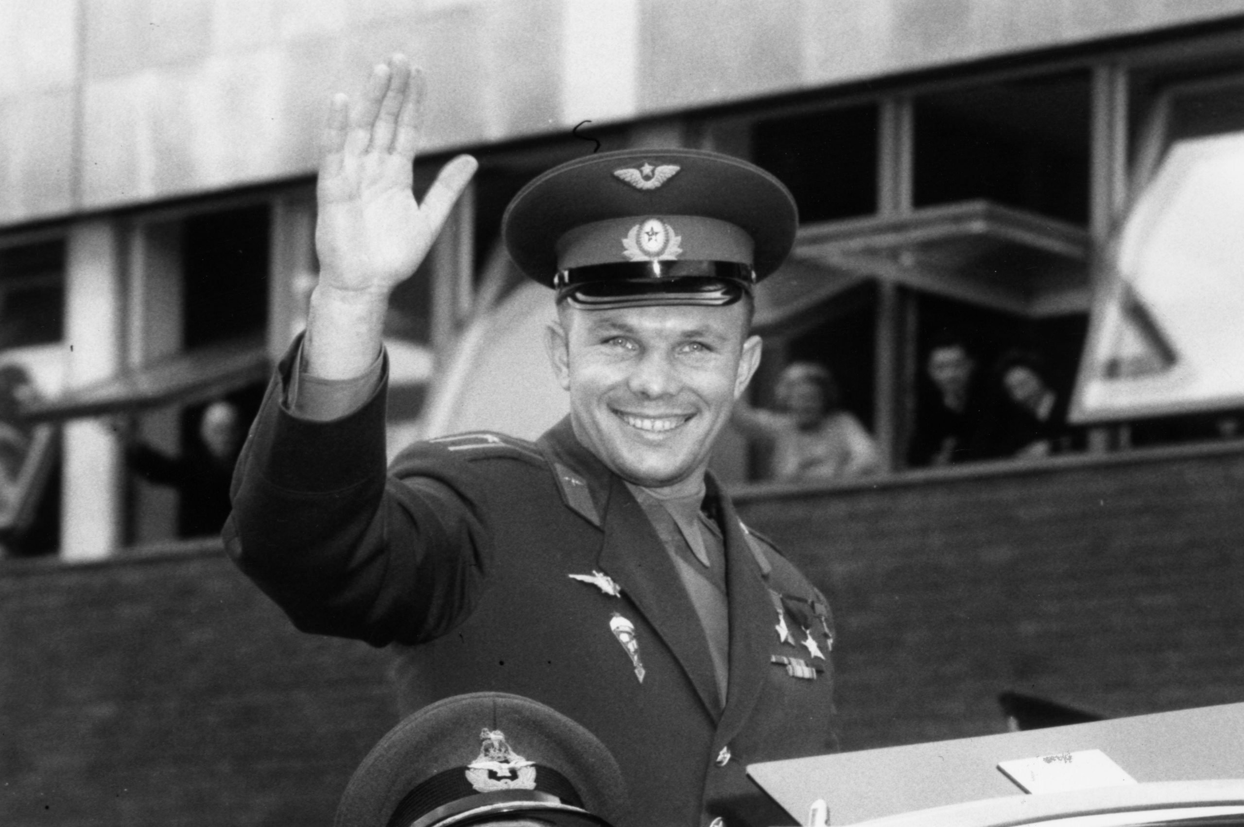 A man in a military uniform waves.