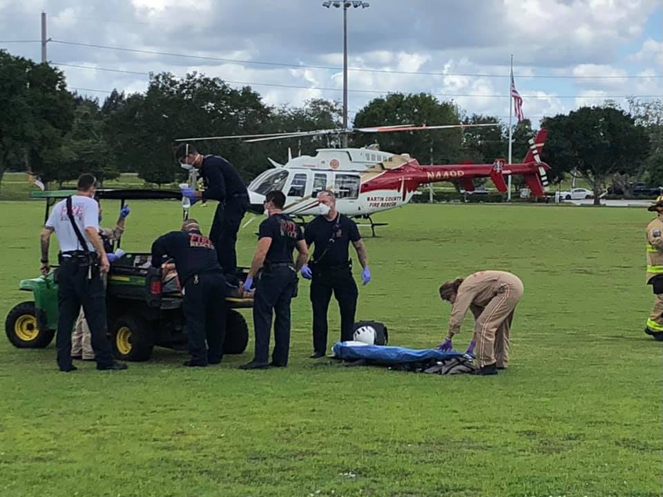 Rescue crews on a field in front of a helicopter after a bicyclist was attacked by an alligator in Florida.