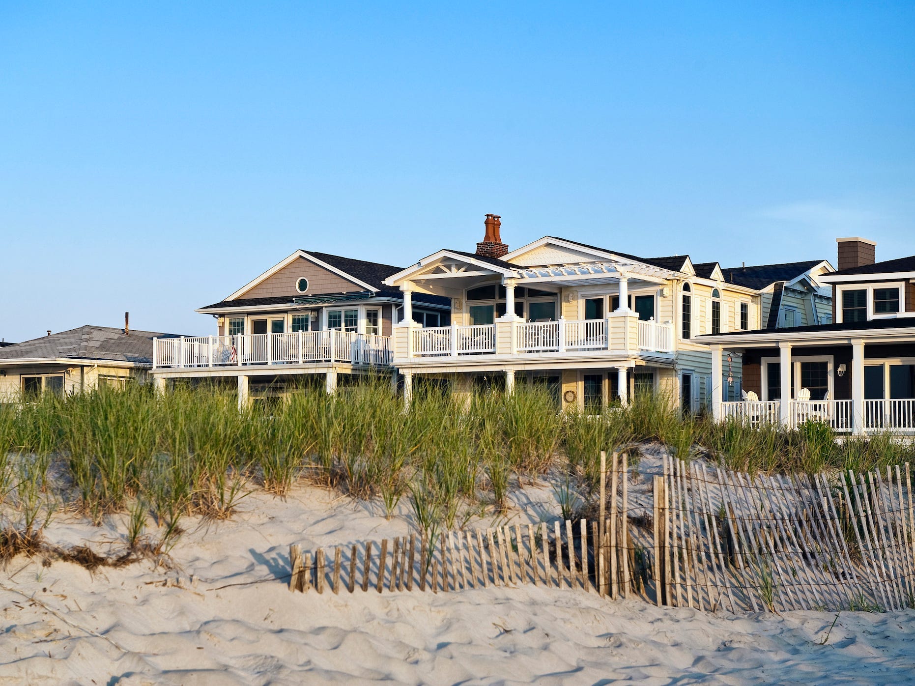 Beach houses pictured with sand dunes in Ocean City, New Jersey.