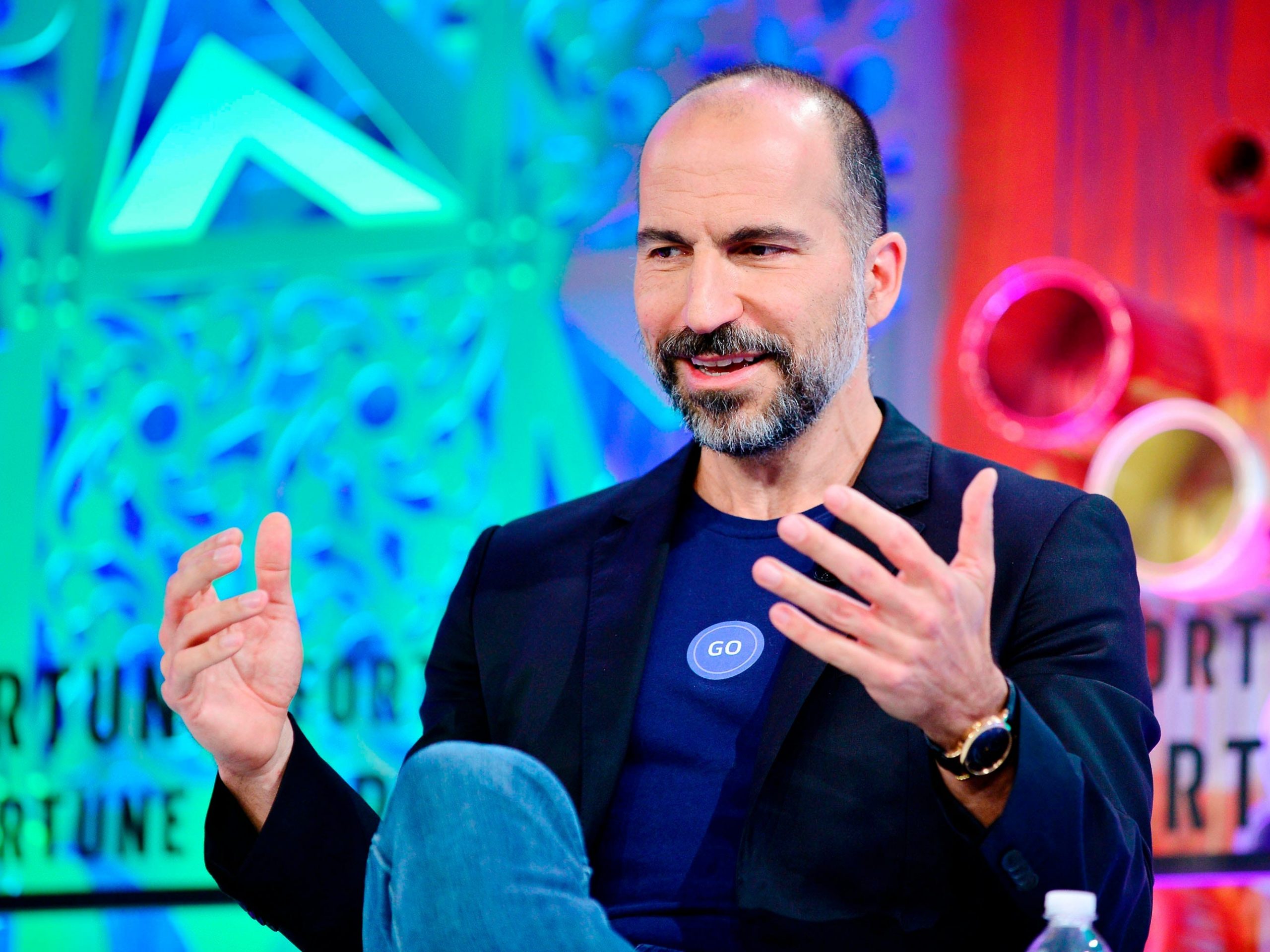 Uber CEO Dara Khosrowshahi is seen sitting on stage speaking during an event