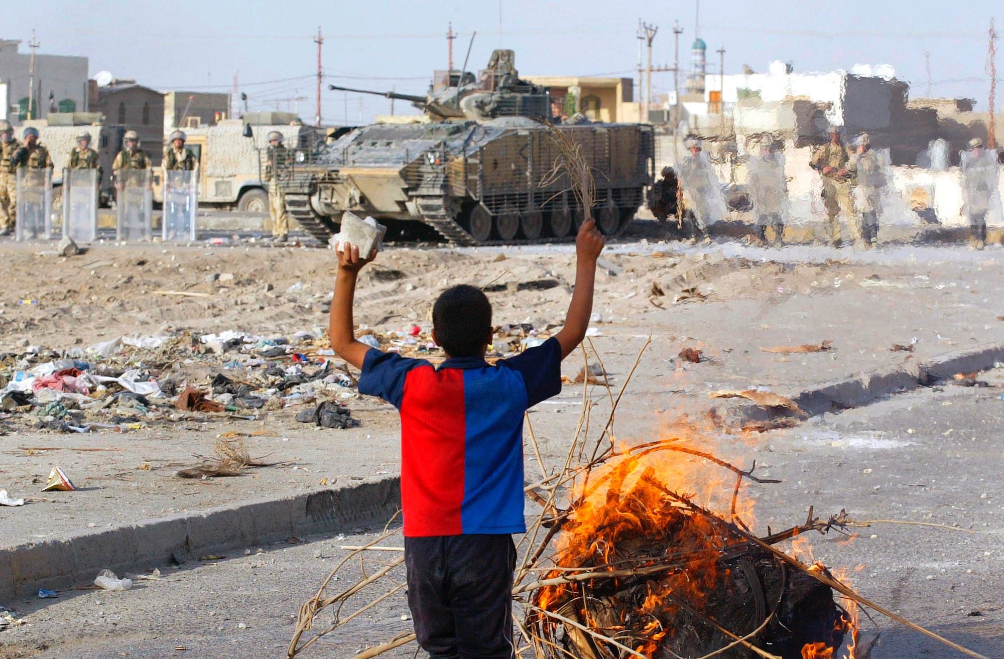 An Iraqi boy taunts British soldiers in Basra Iraq