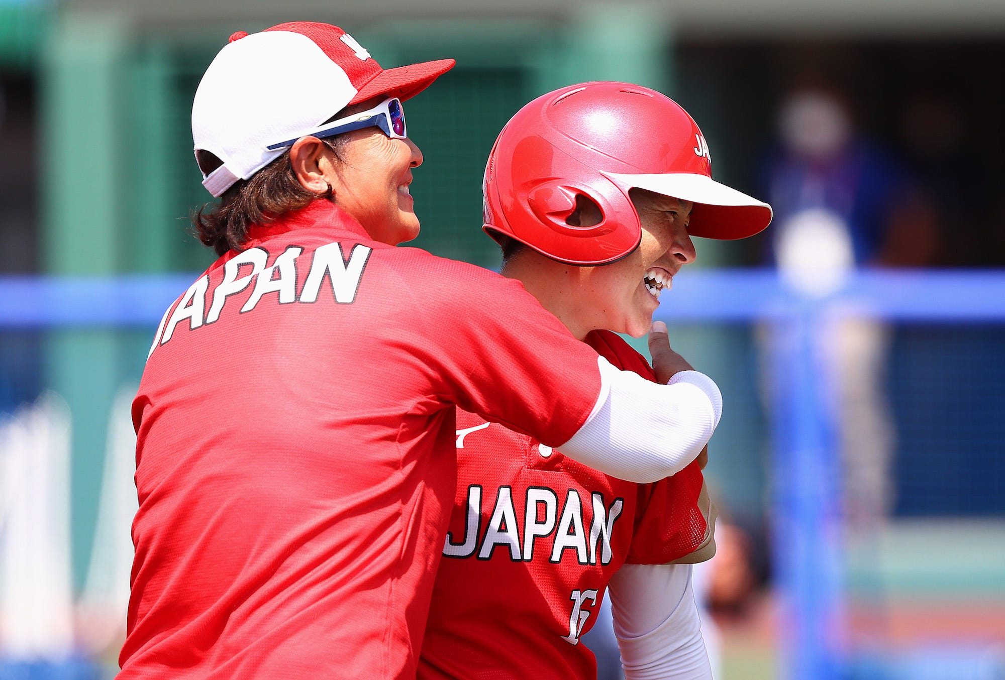 amato Fujita #16 of Team Japan gets a hug from head coach Reika Utsugi after Fujita hit a two-run home run in the fourth inning against Team Australia during the Tokyo 2020 Olympic Games at Fukushima Azuma Baseball Stadium