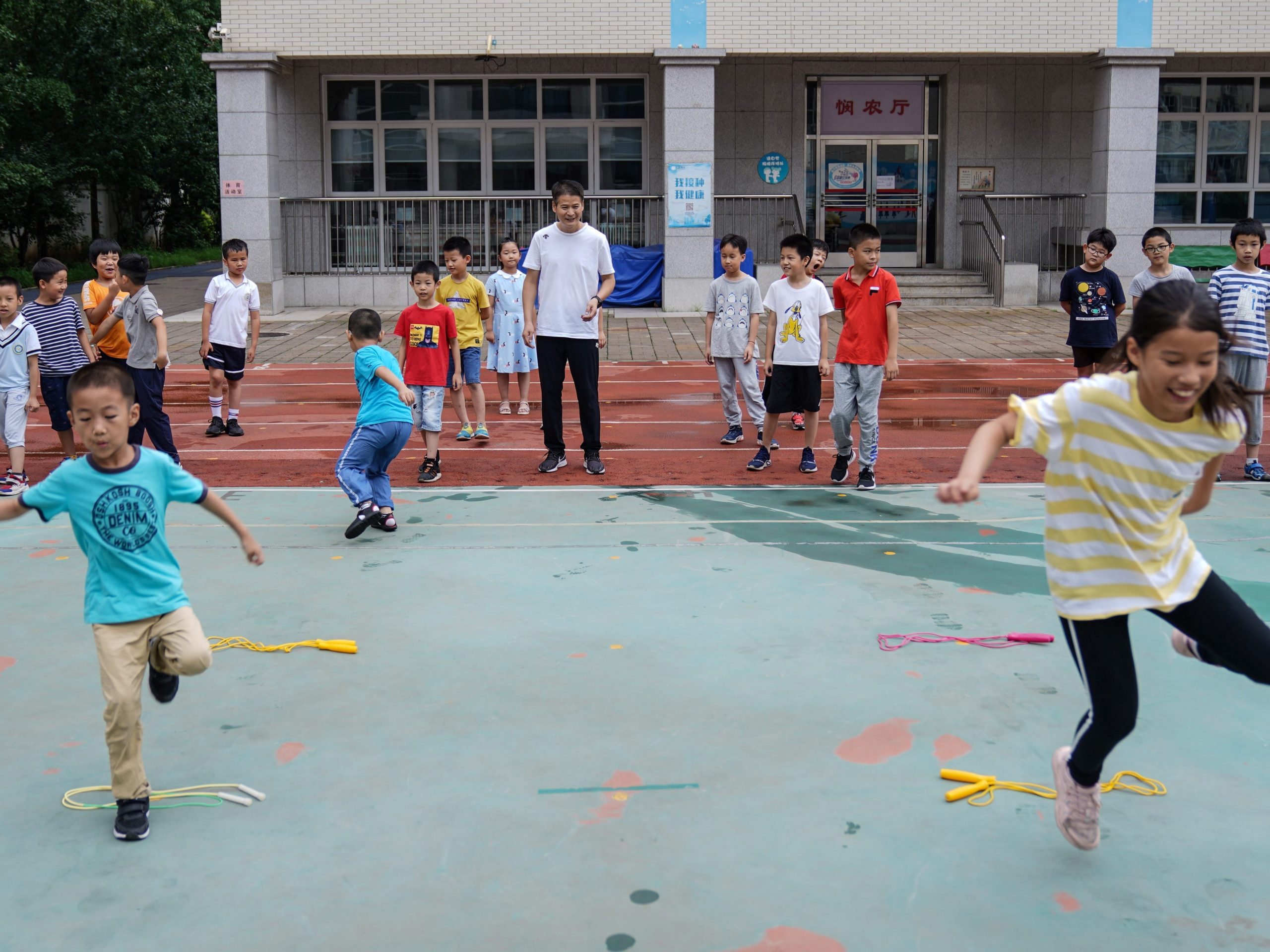 Children take part in outdoor activity with the guidance of teacher at Beijing Primary School in Beijing, capital of China, July 19, 2021.