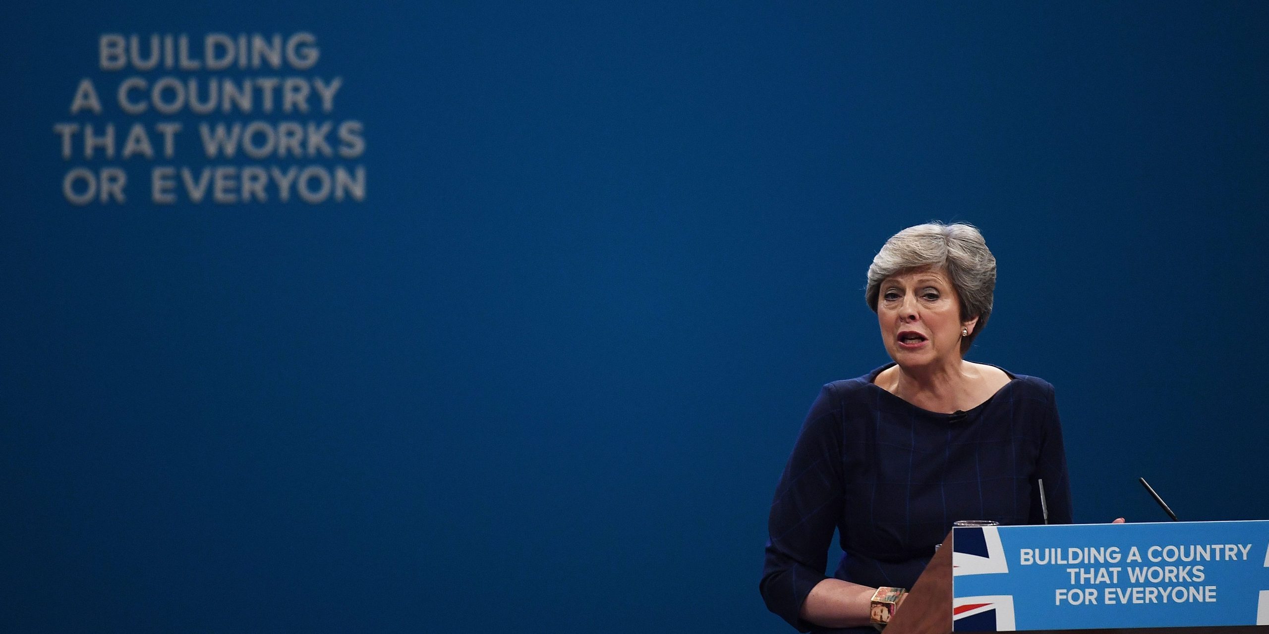 Letters begin to fall off the backdrop, “BUILDING A COUNTRY THAT WORKS OR EVERYON” as British Prime Minister Theresa May delivers her keynote speech to delegates and party members on the last day of the Conservative Party Conference at Manchester Central on October 4, 2017 in Manchester, England.