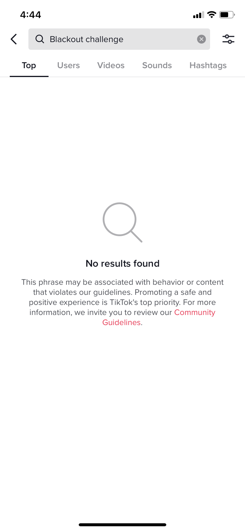 TikTok's user interface, the text "Blackout challenge" is typed into the search bar. The screen shows no results and a statement that the phrase may be associated with behavior or content that violates tiktok's community guidelines.