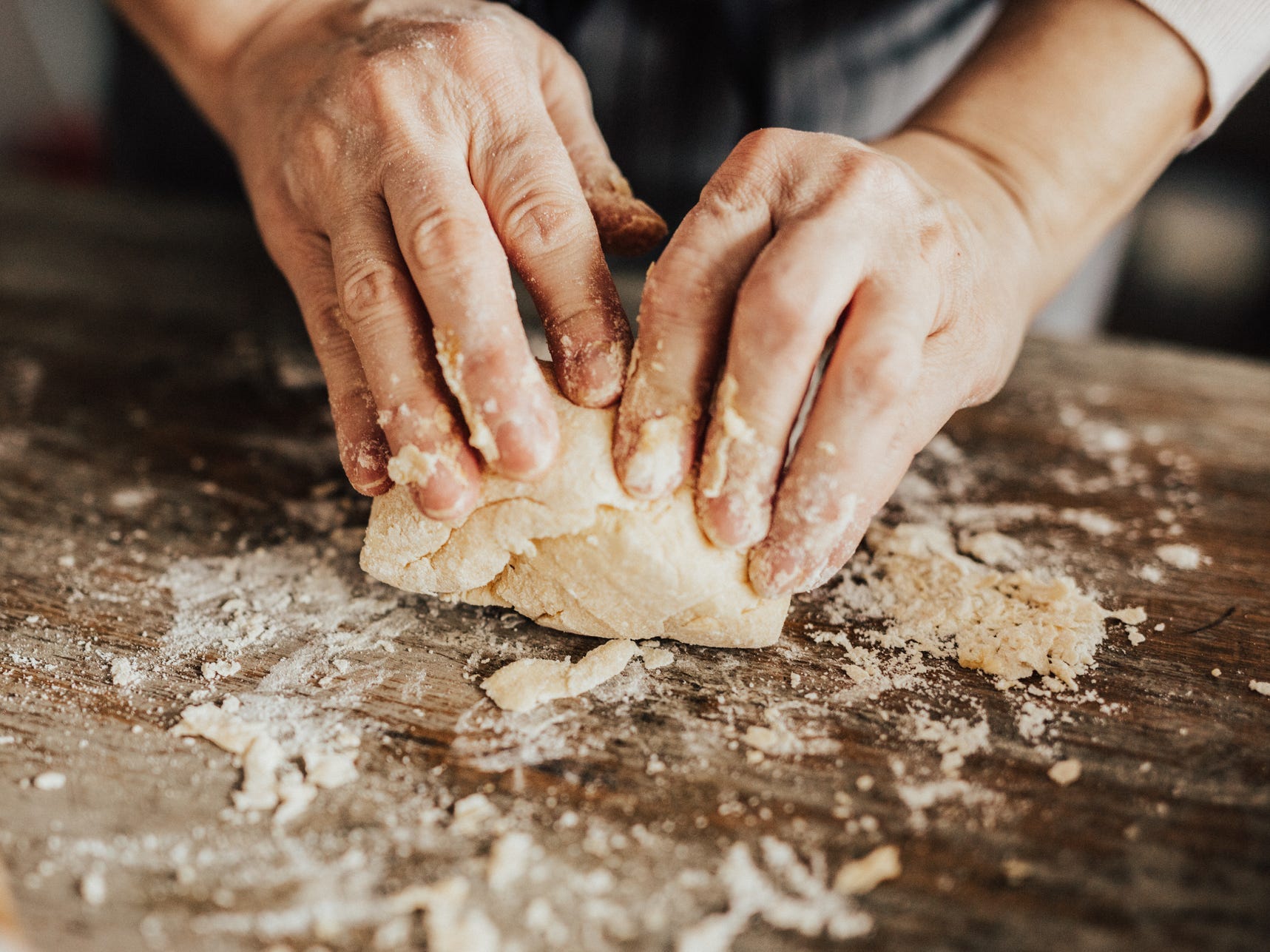 A closeup of hands kneading dough