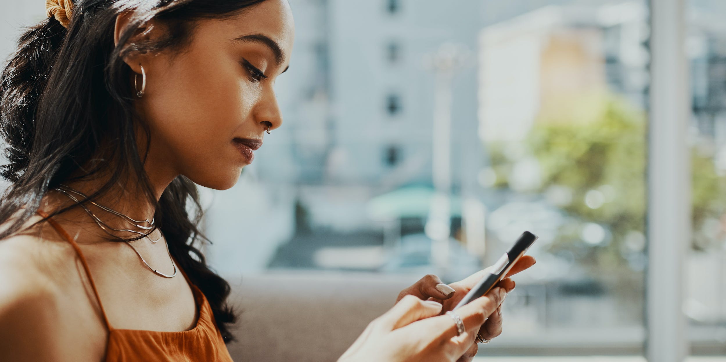 woman looking at phone texting at home