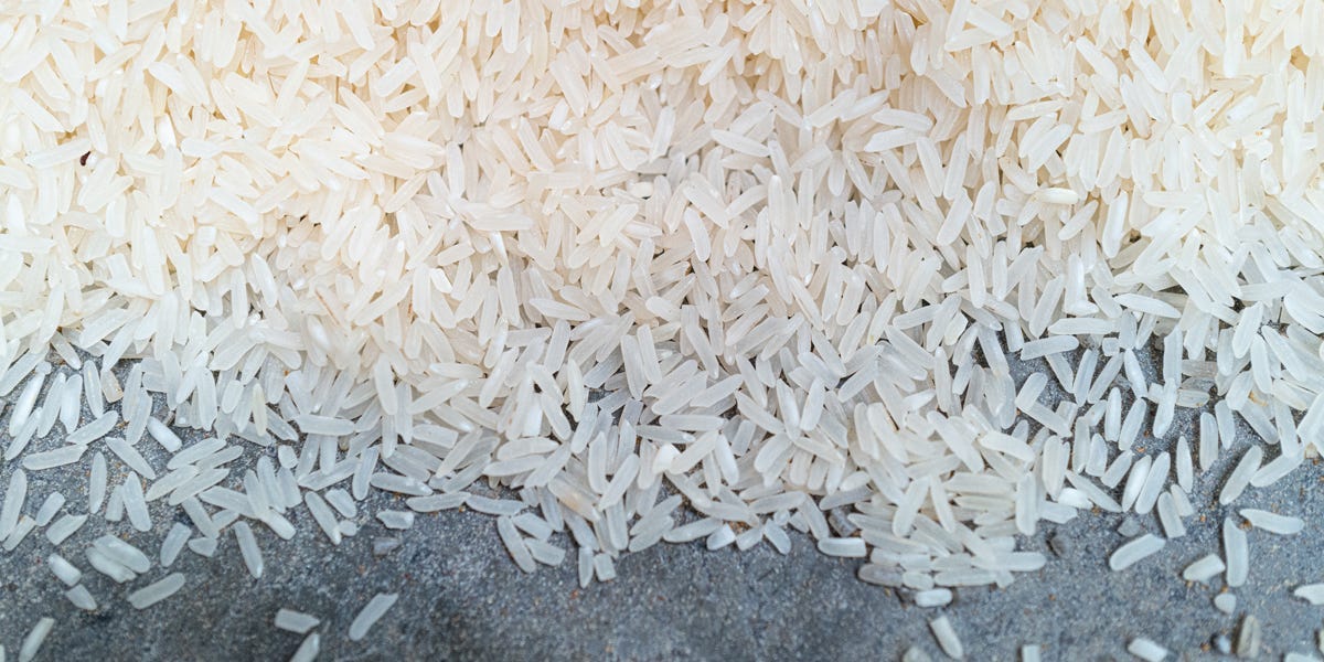 Many grains of rice spilled on a gray table