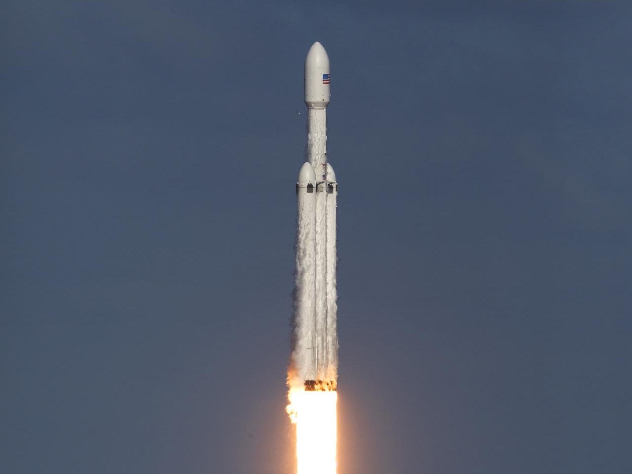 falcon heavy rocket launches engines firing through grey skies