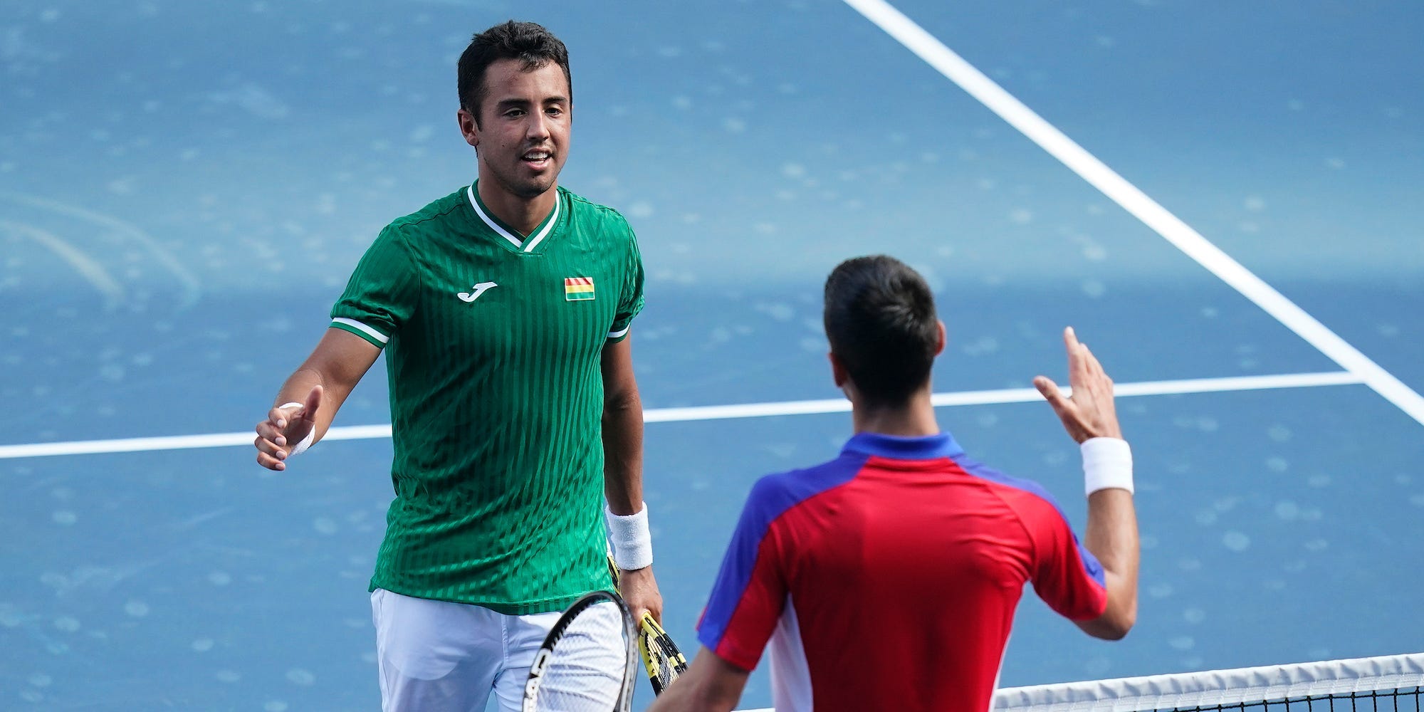 Hugo Dellien and Novak Djokovic shake hands at the Tokyo Olympics.
