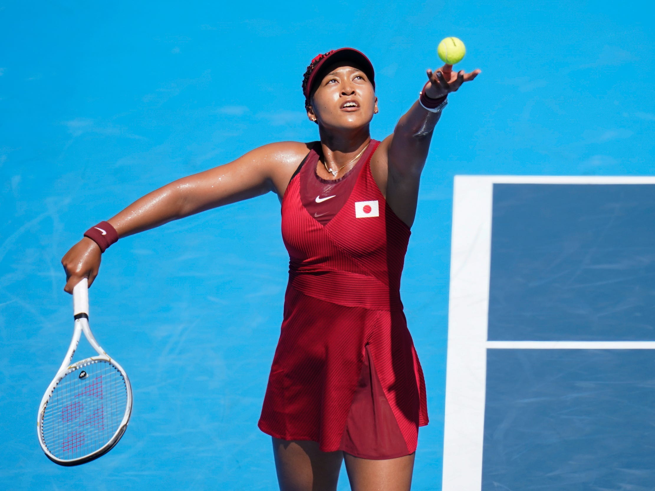 Naomi Osaka serves at the Tokyo Olympics.