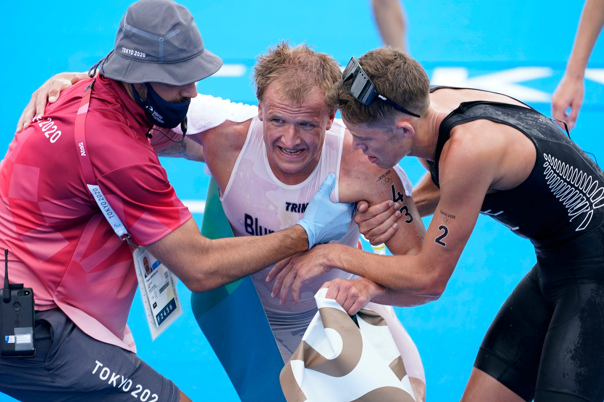 Kristian Blummenfelt is helped up after winning the gold medal in the men's triathlon.