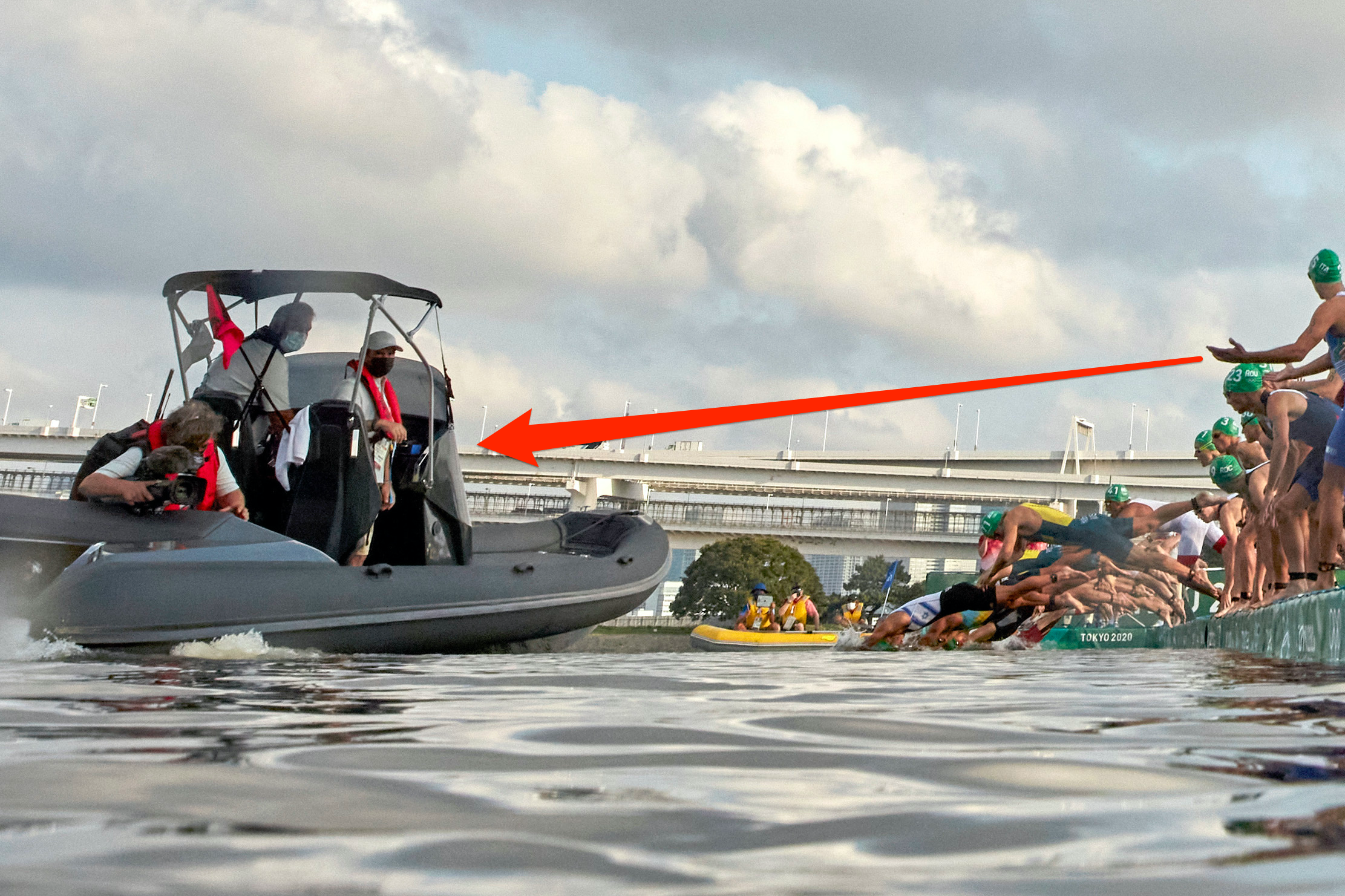 Half the triathlon swimmers look bemused as others dive in, unobstructed by a broadcast boat.