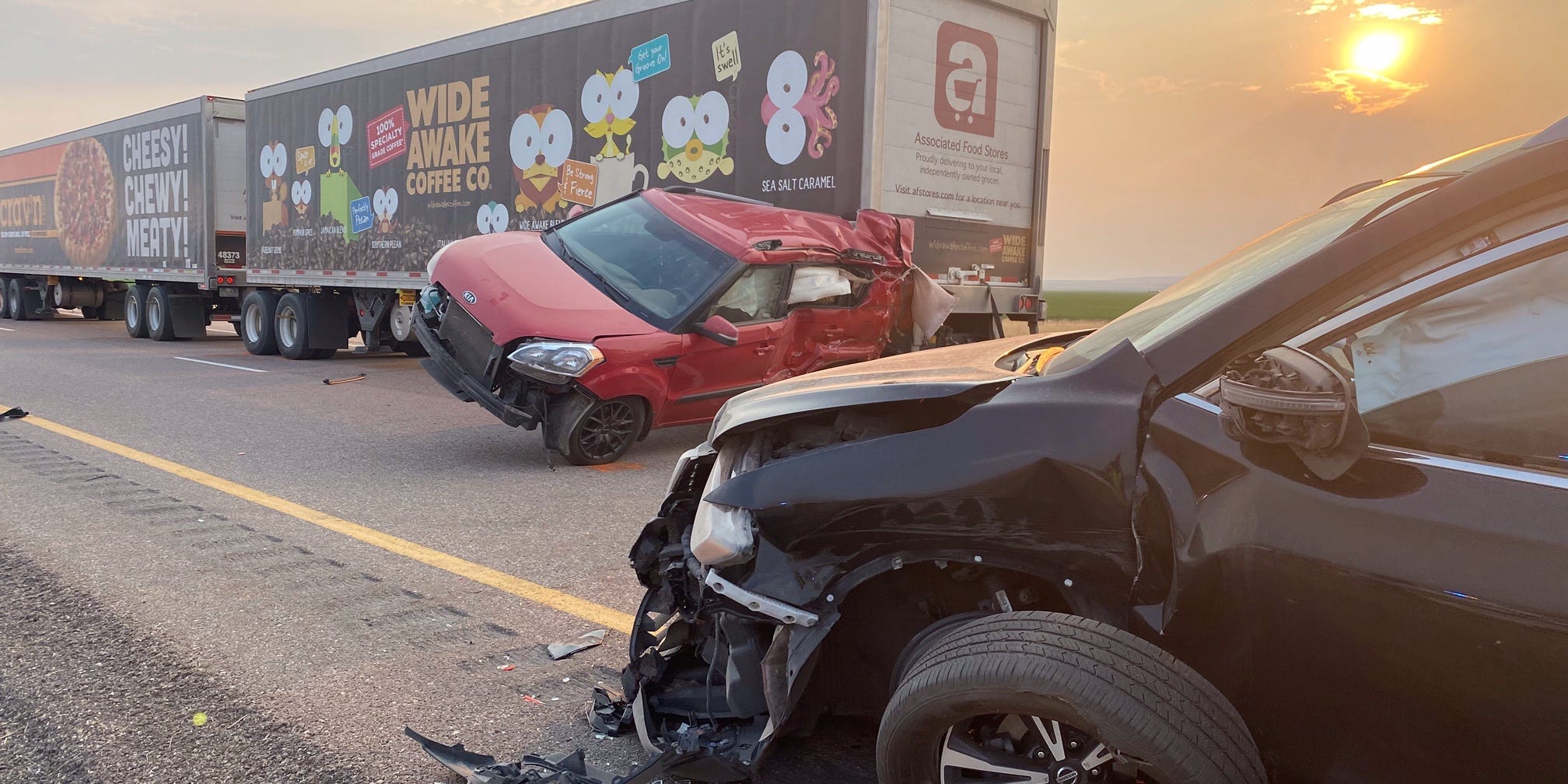 Two cars and a truck on a road, with some damage