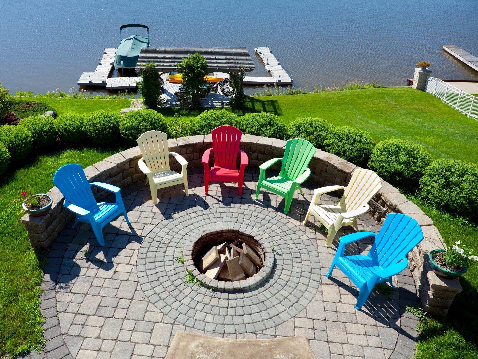 A fire pit set in a circular stone patio overlooking a dock