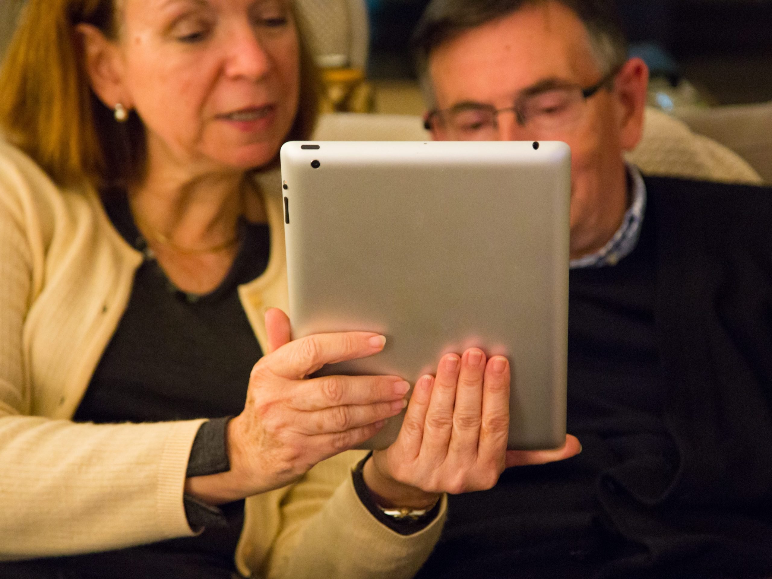 Grandparents having a FaceTime conversation with his granddaughters on an iPad.