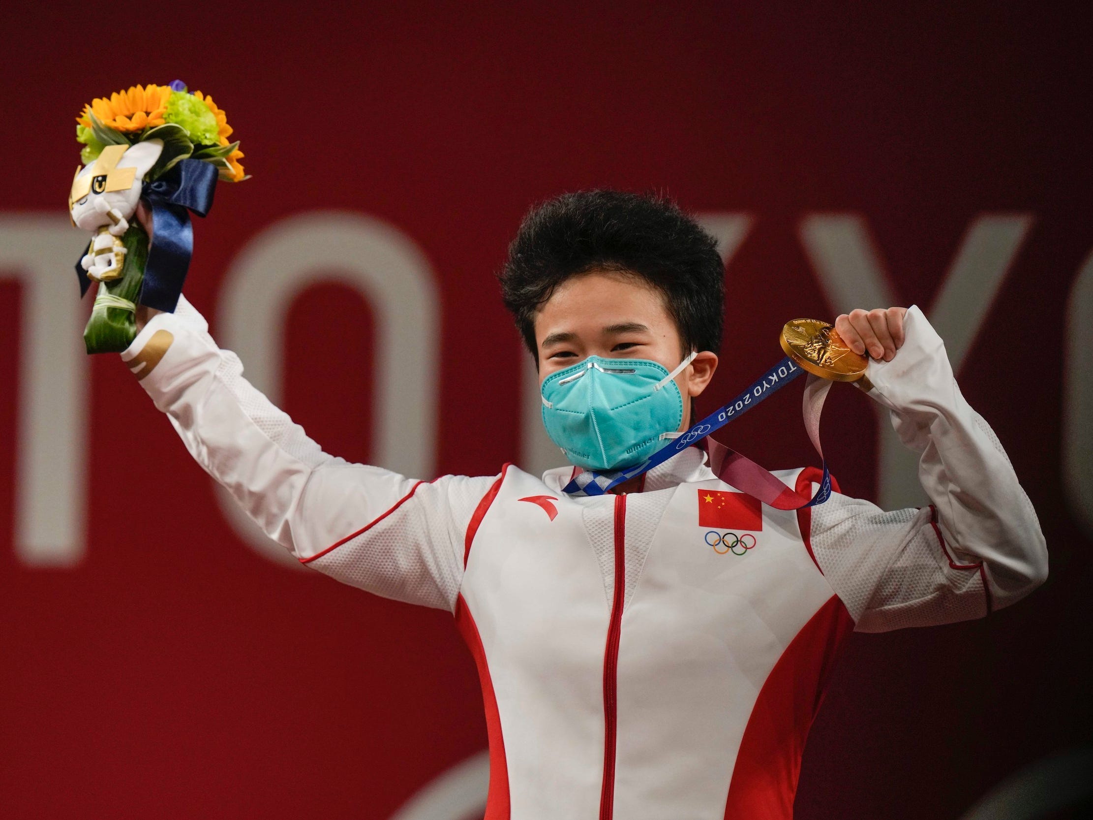 Zhihui Hou brandishes her Olympic gold medal.