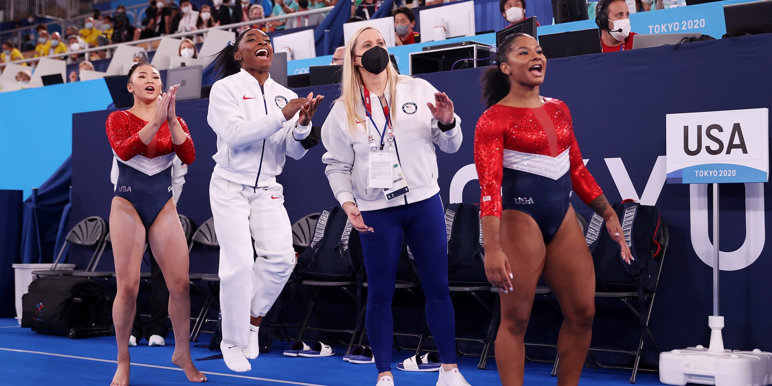Sunisa Lee, Simone Biles, coach Cecile Landi, and Jordan Chiles of Team United States react during the Women's Team Final on day four of the Tokyo 2020 Olympic Games at Ariake Gymnastics Centre on July 27, 2021 in Tokyo, Japan.