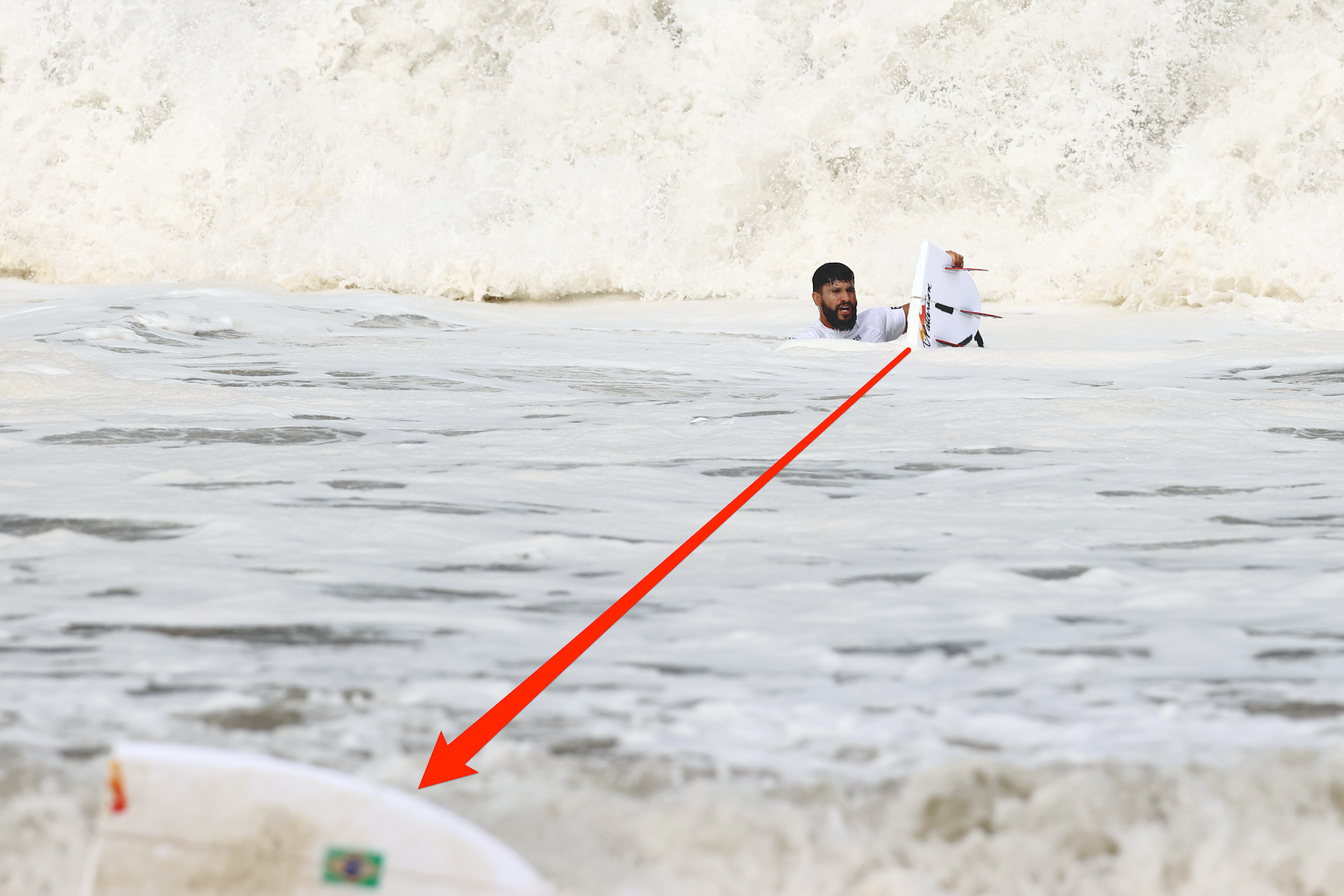 Italo Ferreira of Team Brazil holds half of his broken board during the men's surfing final at the 2020 Olympic Games.