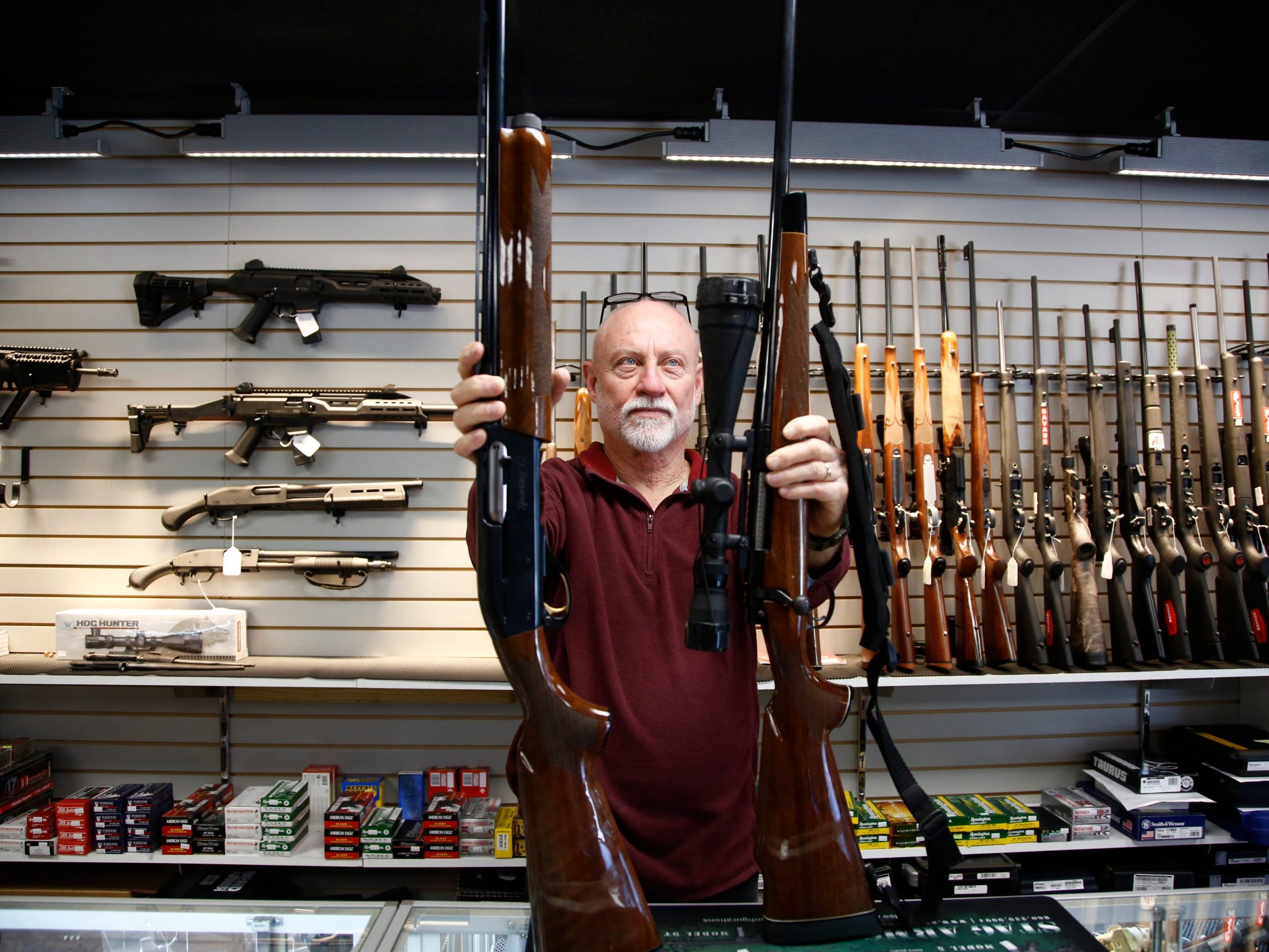 Bret Reid shows off a Remington 700 hunting rifle and a Remington 1100 shotgun available for sale at Atlantic Outdoors gun shop on March 26, 2018 in Stokesdale, North Carolina.