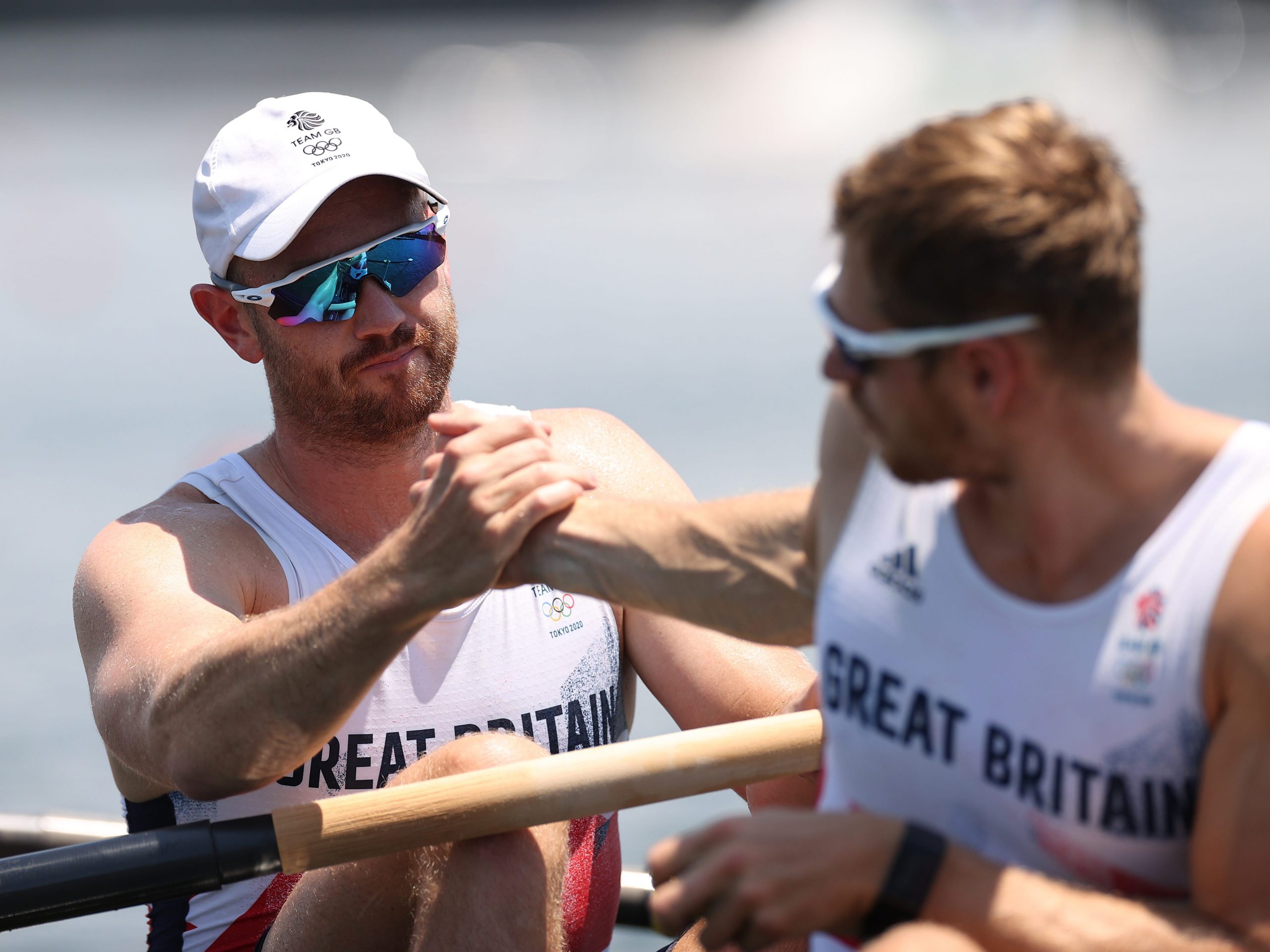 Matthew Rossiter shaking hands with teammate Rory Gibbs at the Tokyo Olympics