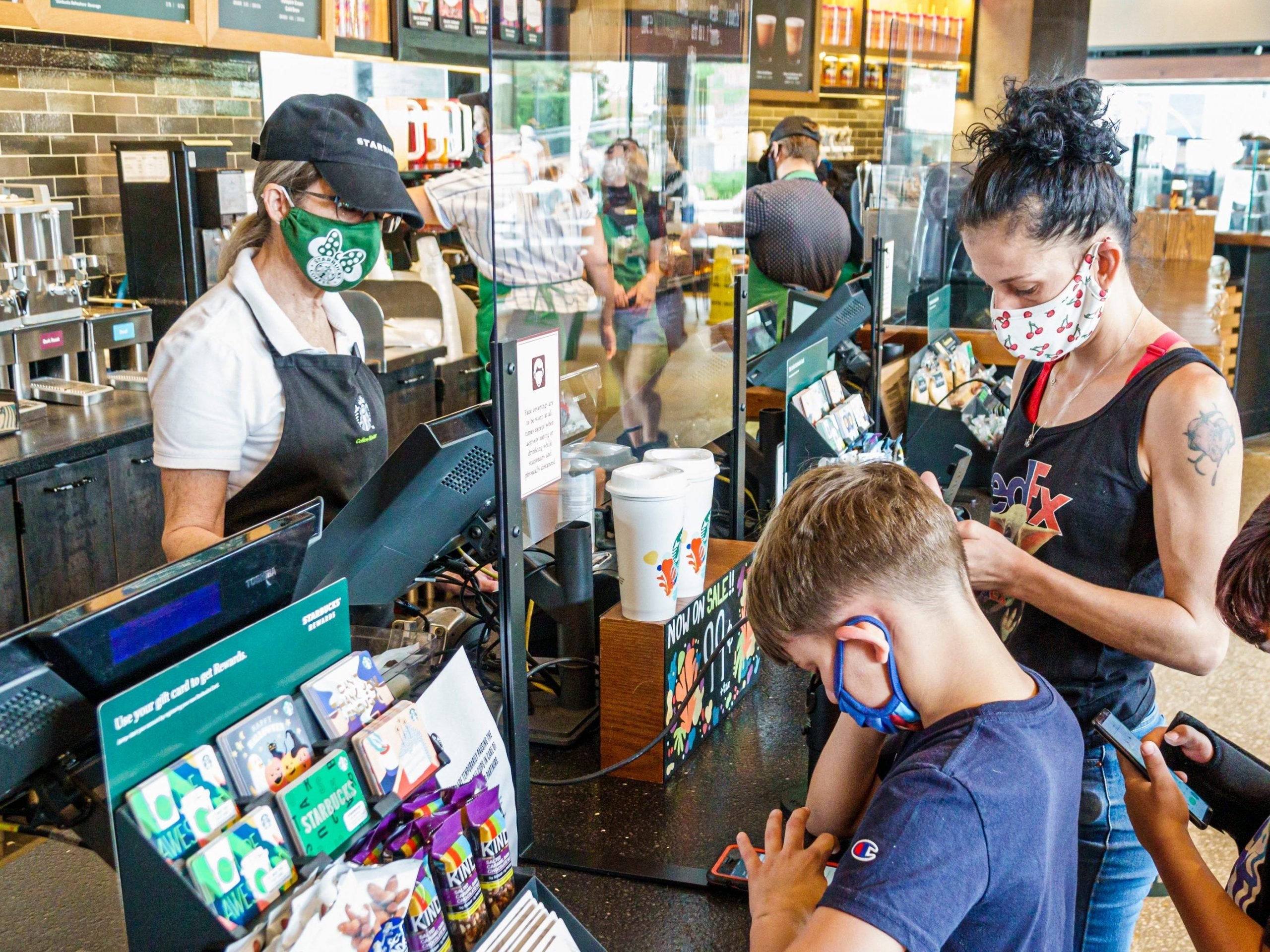 Florida, Orlando, Starbucks Coffee shop, mom with sons at cashier, all wearing face masks