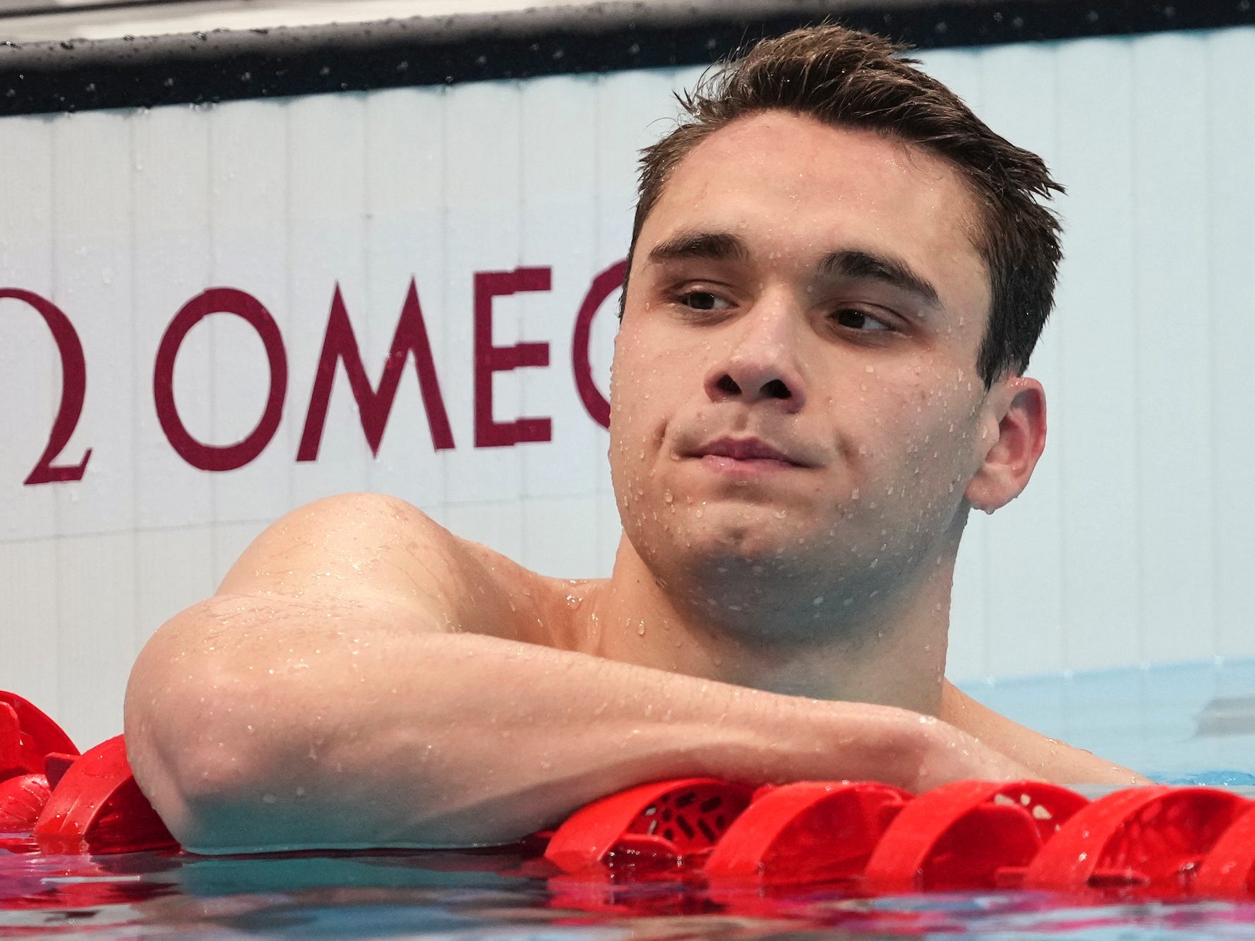 Kristof Milak rests in the pool after winning the men's 200-meter butterfly at the Tokyo Olympics.