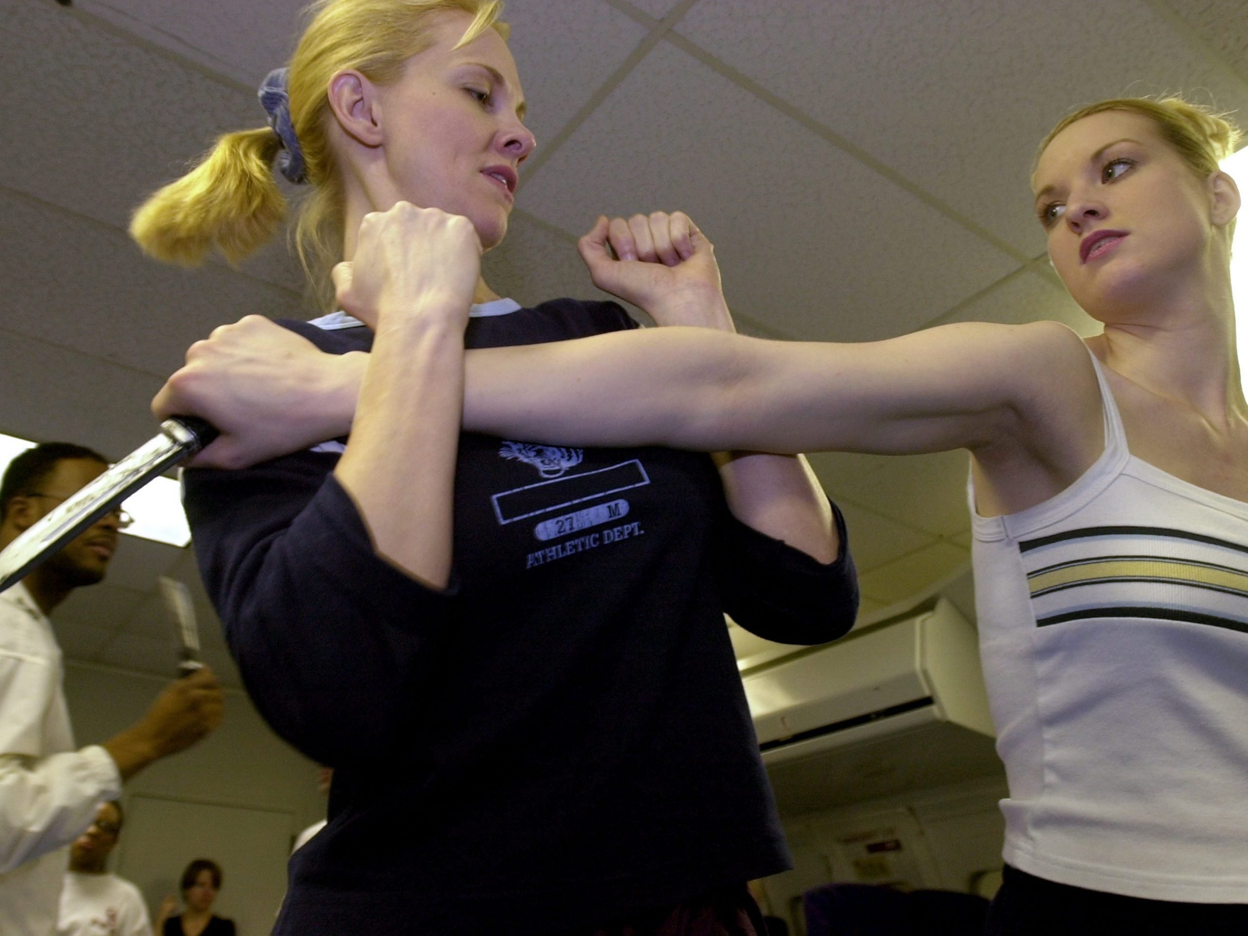 A woman throws a punch at a second woman, who blocks it, during a training.