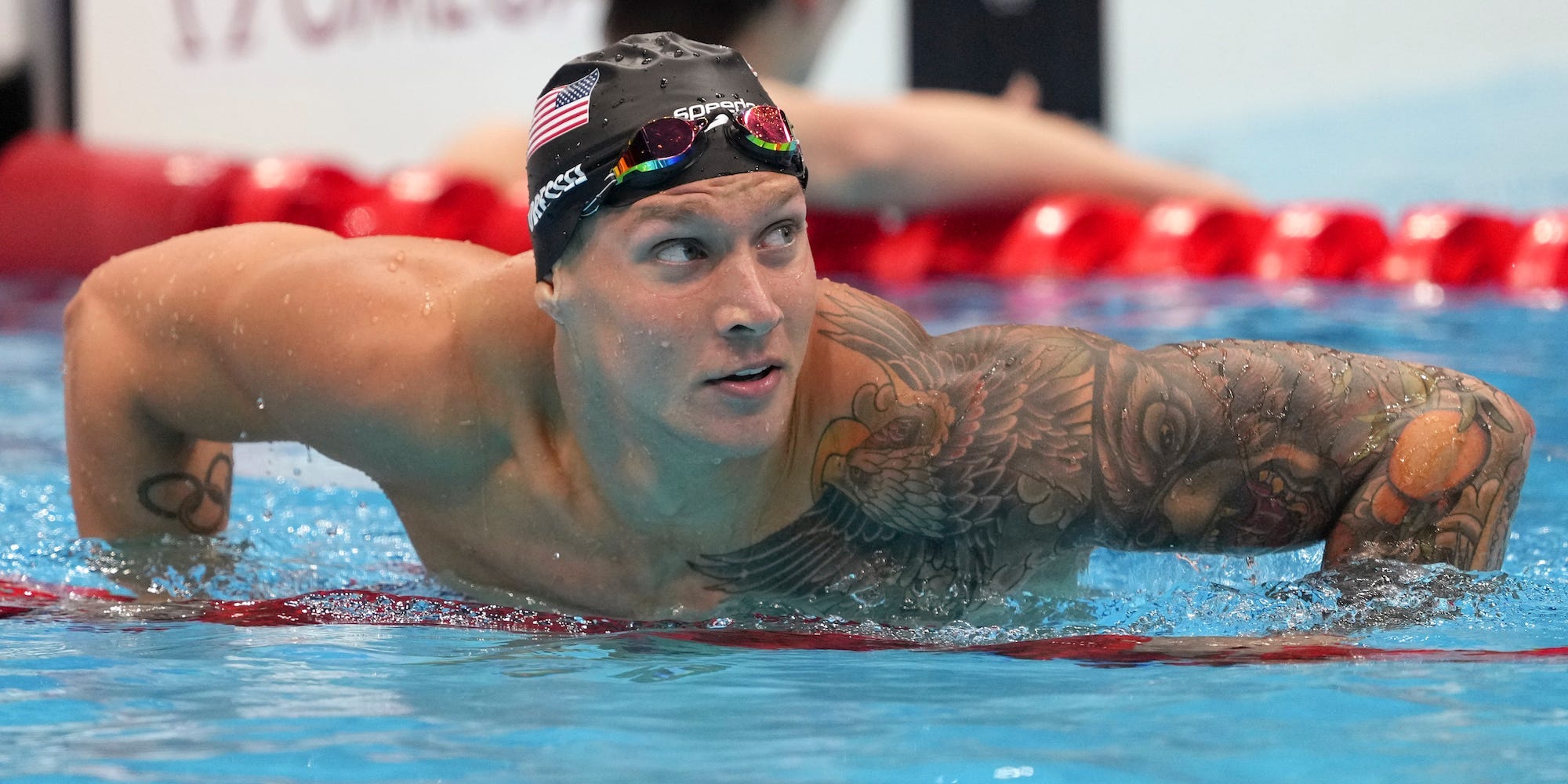 Caeleb Dressel hangs on the lane lines and looks up at the Tokyo Olympics.