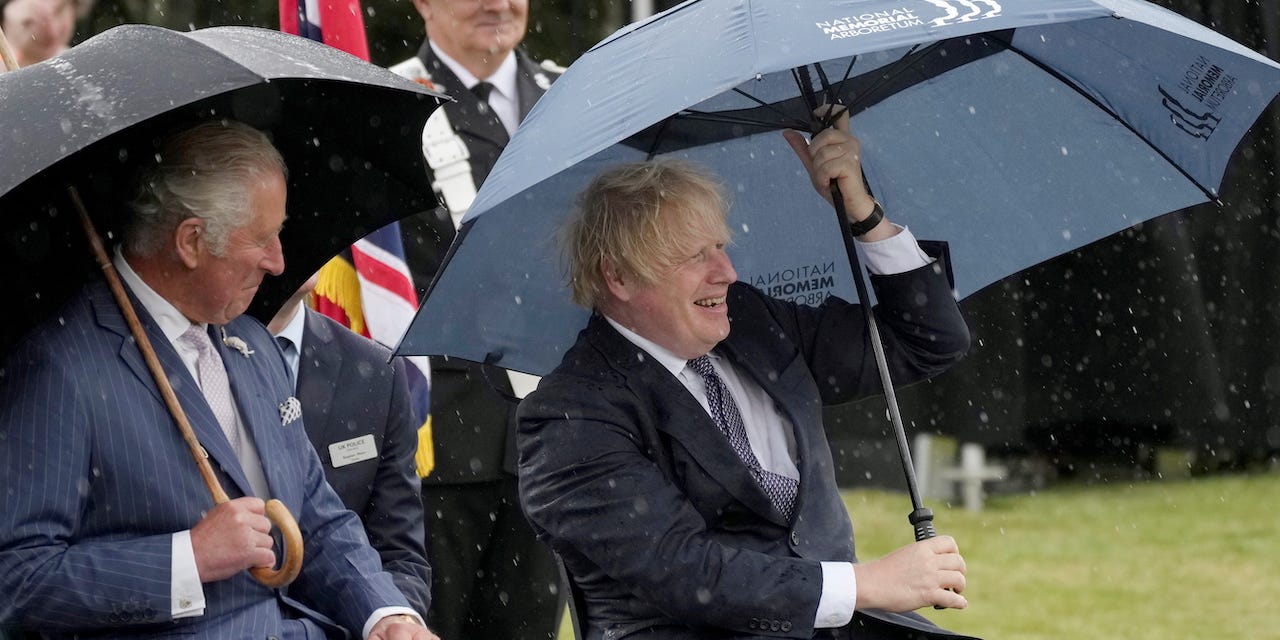 Britain's Prince Charles looks on as Prime Minister Boris Johnson opens his umbrella at The National Memorial Arboretum at Alrewas, Staffordshire, Britain July 28, 2021.