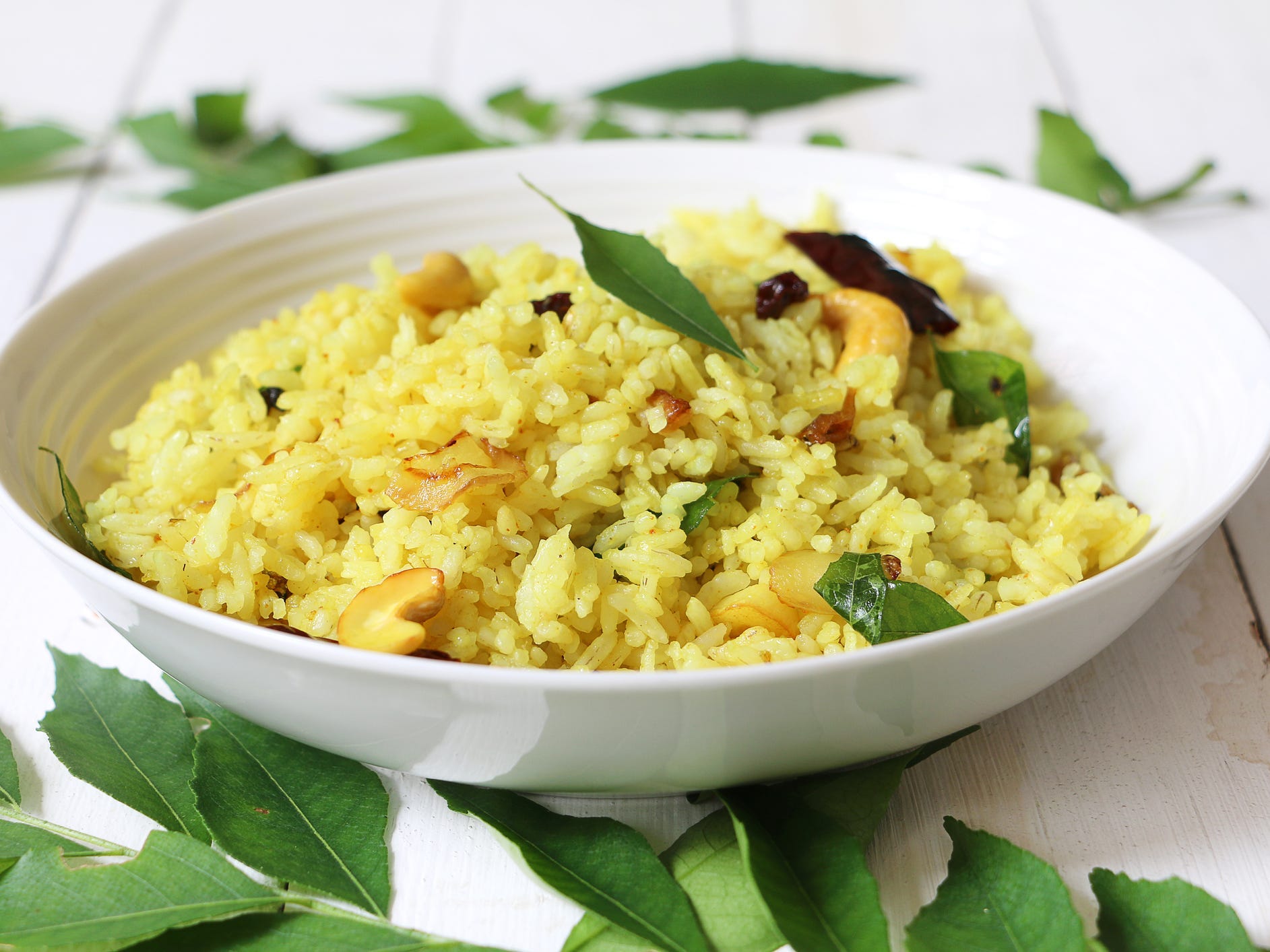 A bowl of rice pilaf with raisins and cashews mixed in