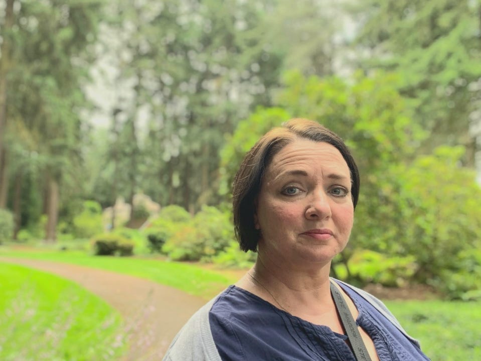 A woman outside looking at the camera