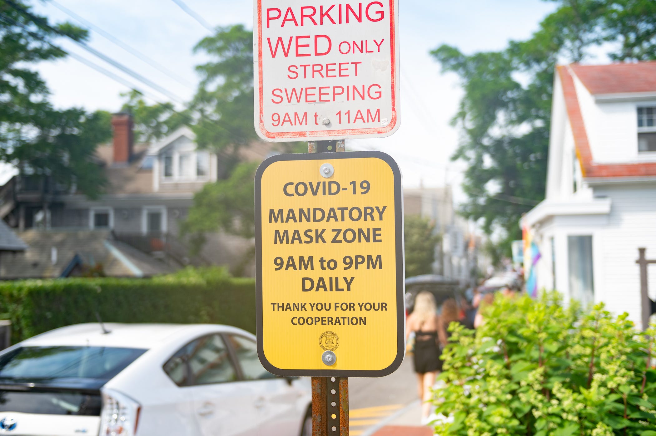 street sign attached to parking pole says 'covid-19 mandatory mask zone 9 am to 9 pm daily'