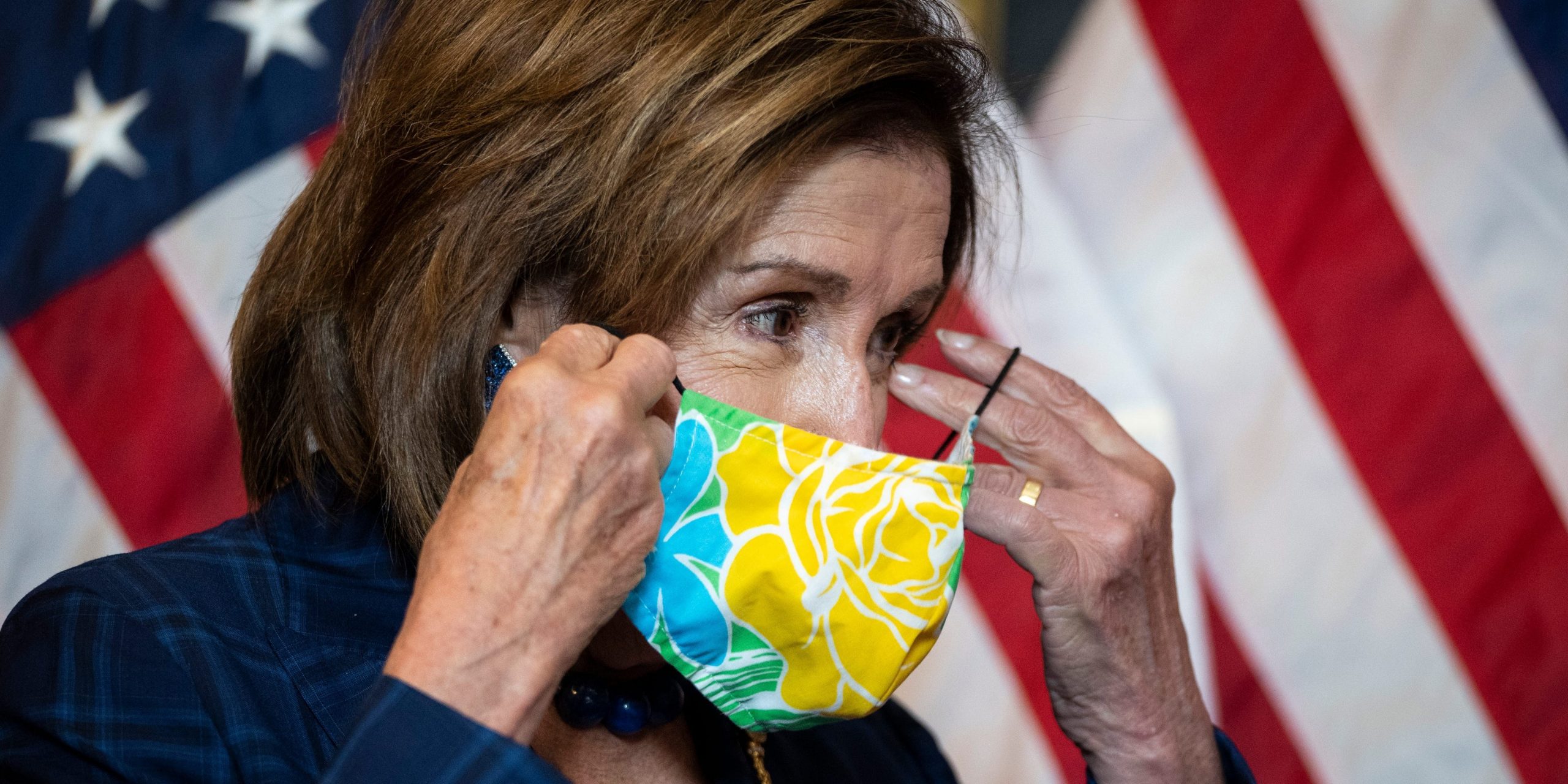 Speaker of the House Nancy Pelosi puts on her face mask on July 30, 2021.