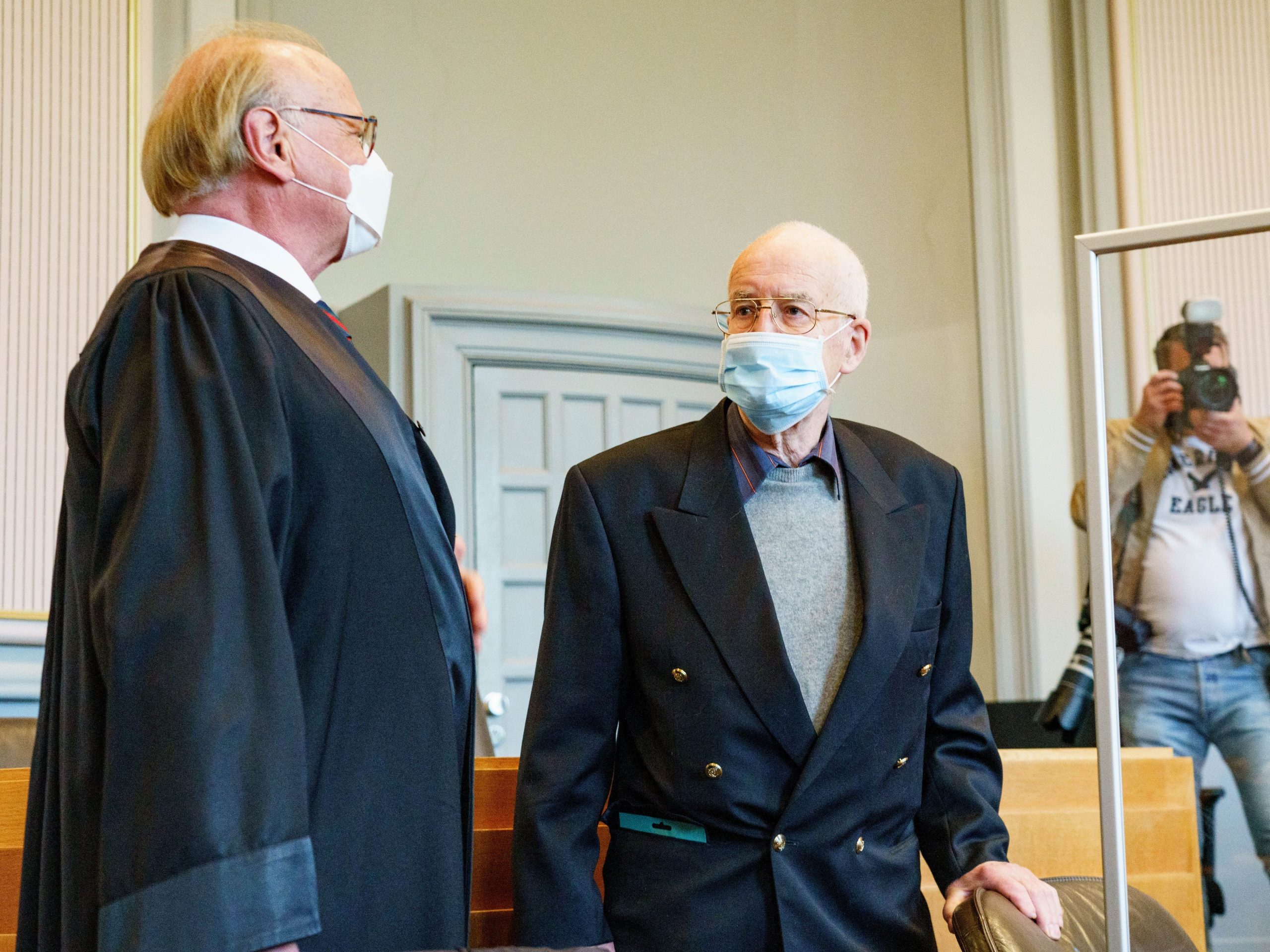 he 84-year-old accused of possession of a tank (M) and his lawyer Gerald Goecke (l), wait in the courtroom for the start of the trial.