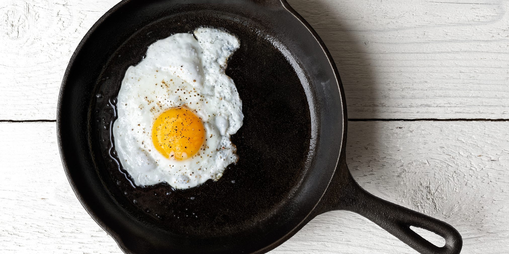 A fried egg in a cast iron skillet.