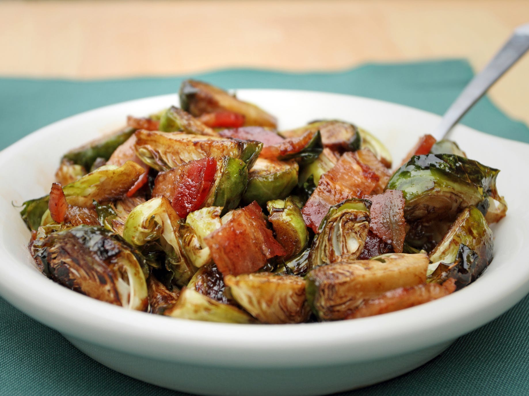 A bowl of charred Brussels sprouts studded with pieces of bacon