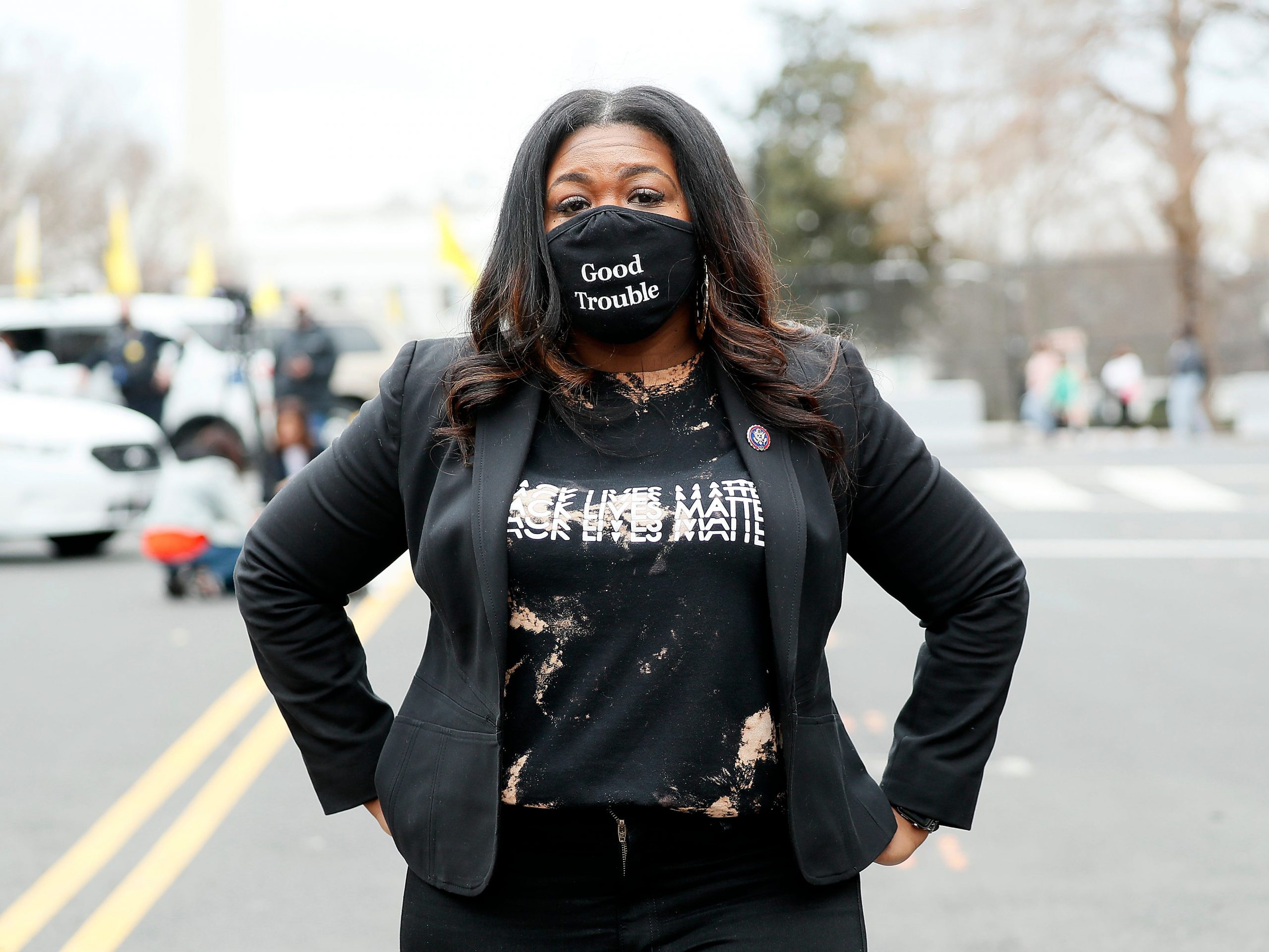 Rep. Cori Bush (D-MO) attends The National Council for Incarcerated Women and Girls "100 Women for 100 Women" rally in Black Lives Matter Plaza near The White House on March 12, 2021 in Washington, DC. She stands with her hands on her hips and is wearing a Black Lives Matter t-shirt and a mask that reads "Good Trouble."