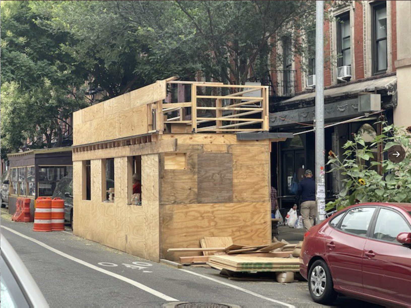 A photo shows a two-story outdoor dining shed under construction in NYC's Lower East Side.