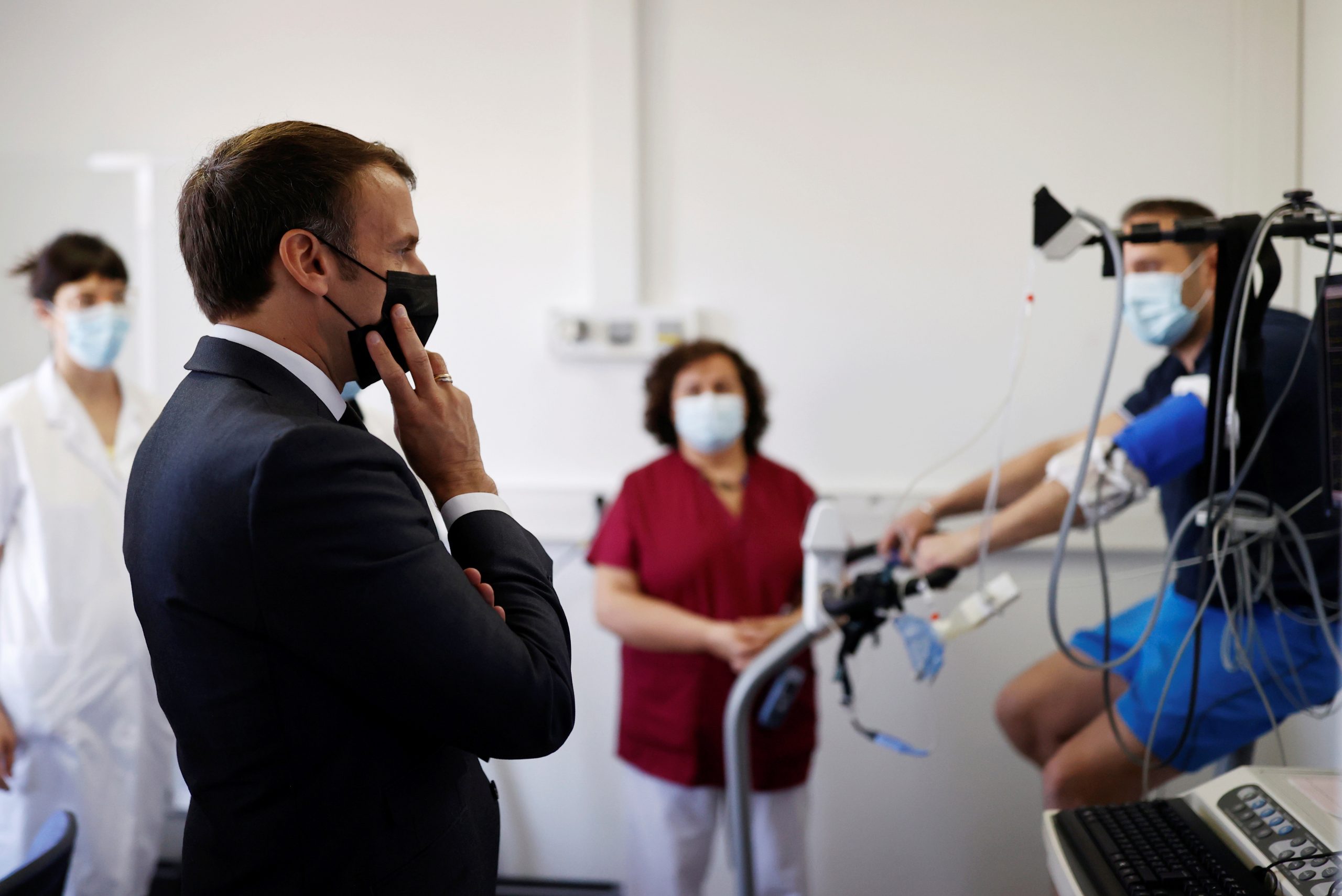 President Macron praat met de medische staf van een ziekenhuis in de buurt van Parijs. Foto: EPA/Christian Hartmann