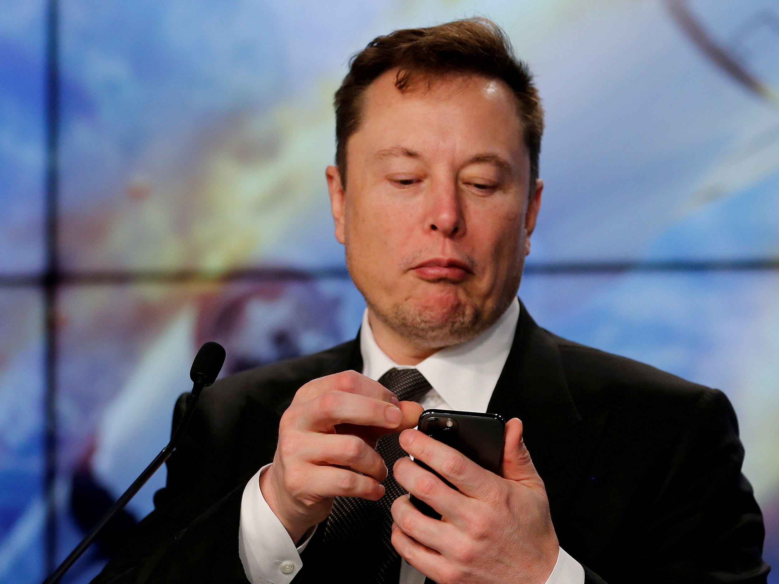 Elon Musk looking at his iPhone .JPG