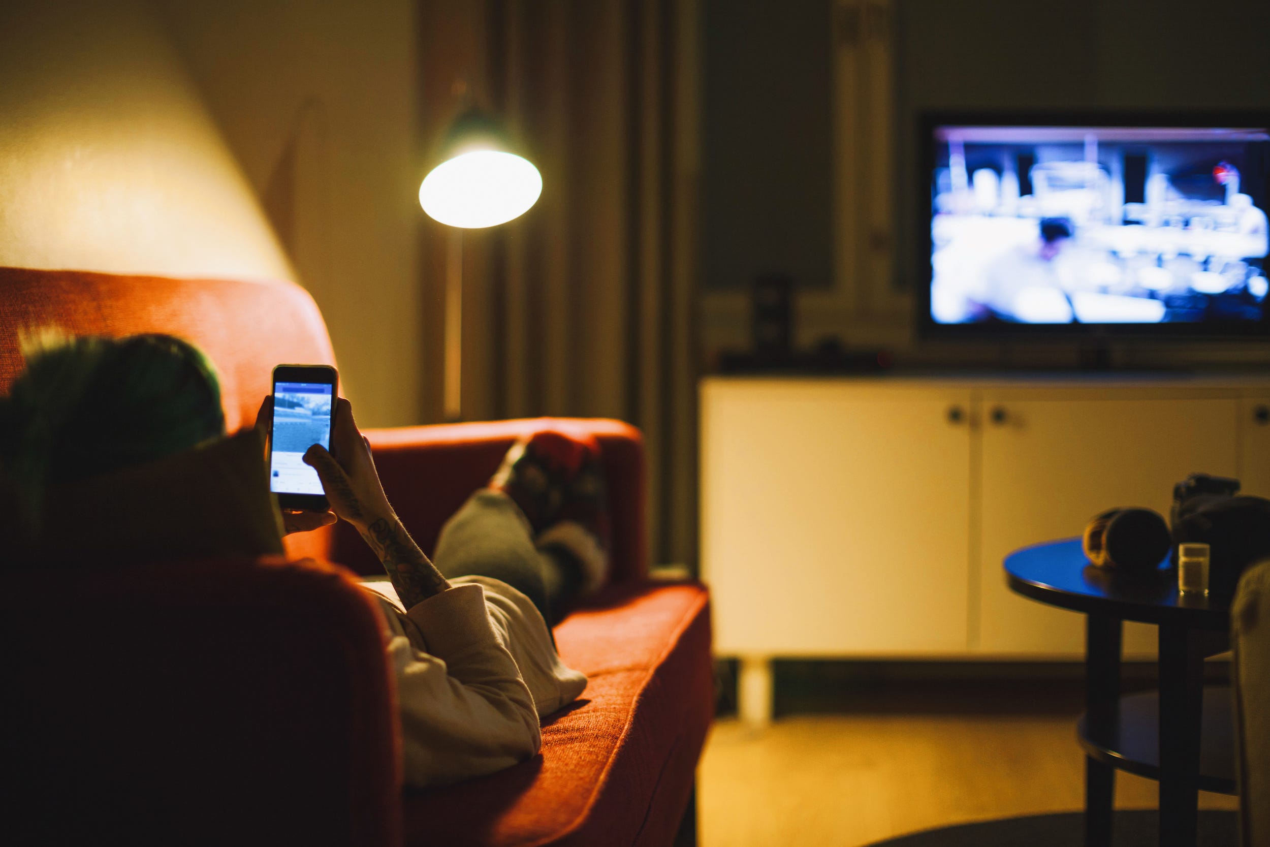 relaxing on couch with smartphone mirroring to TV