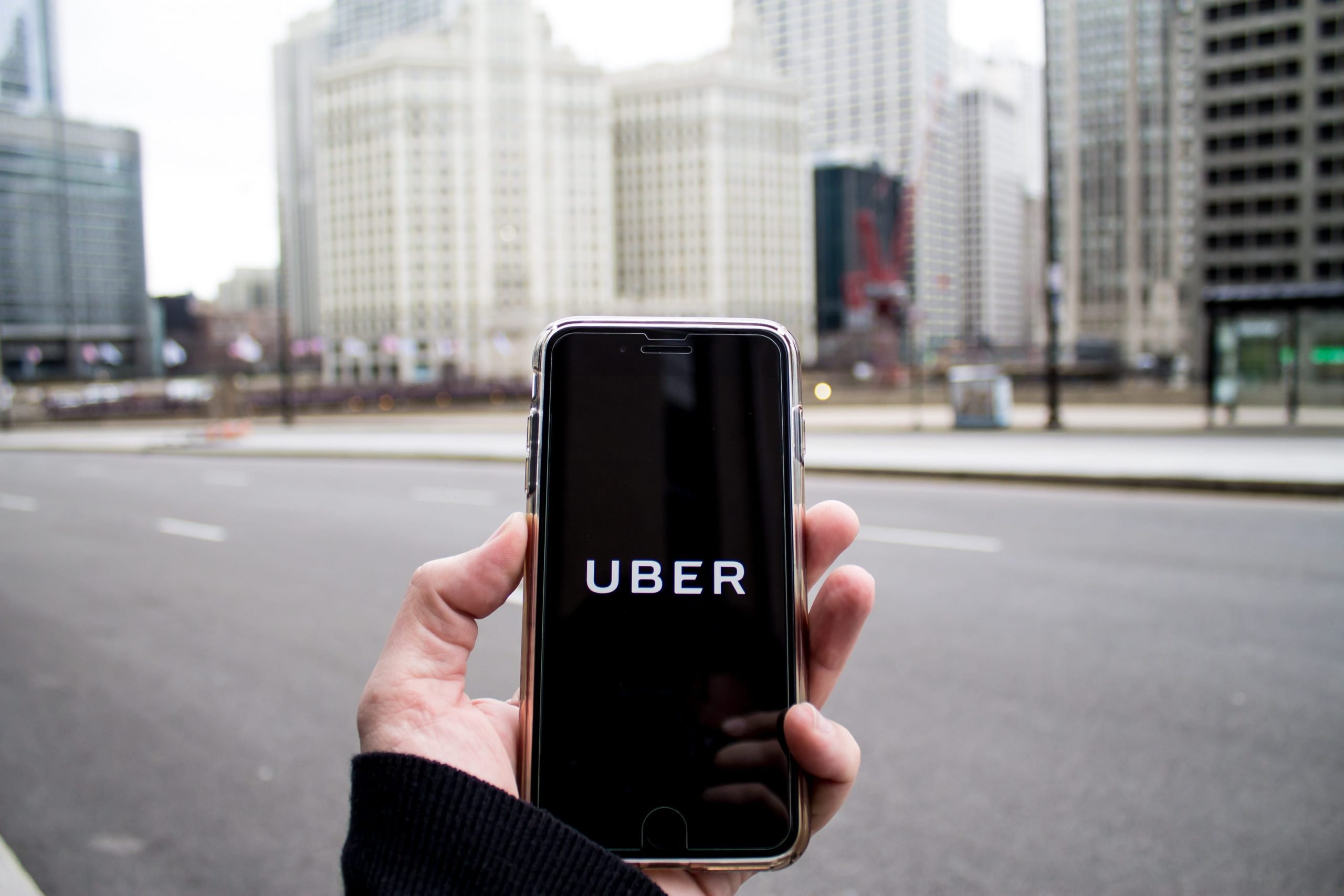 uber app open in front of chicago skyline