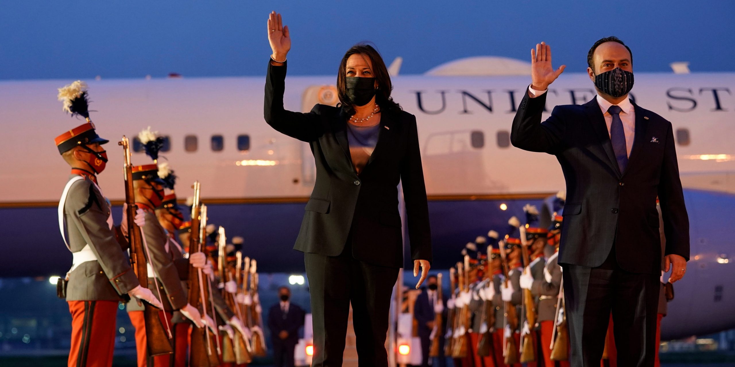 Kamala Harris Pedro Brolo stand in front the Guatemalan Air Force Central Command at night, waving.